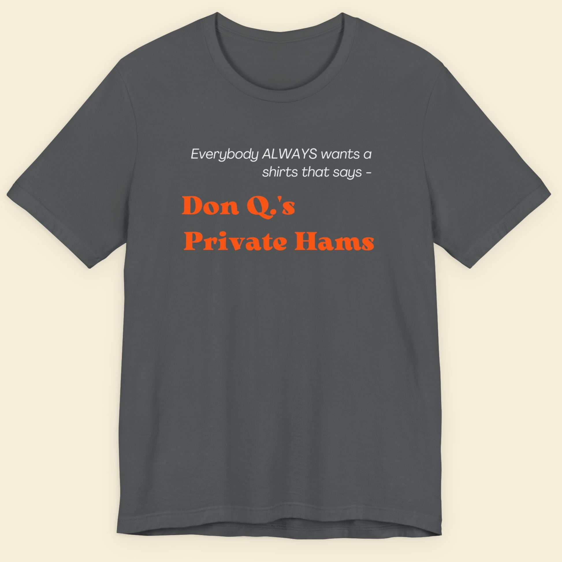 Gray t-shirt with humorous text design on a beige background.