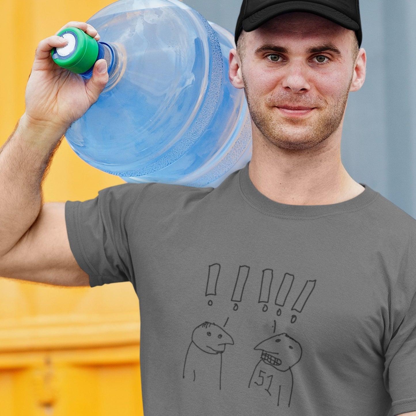 Man wearing a dark grey Light grey t-shirt with a line drawing carrying a water bottle on a dock.