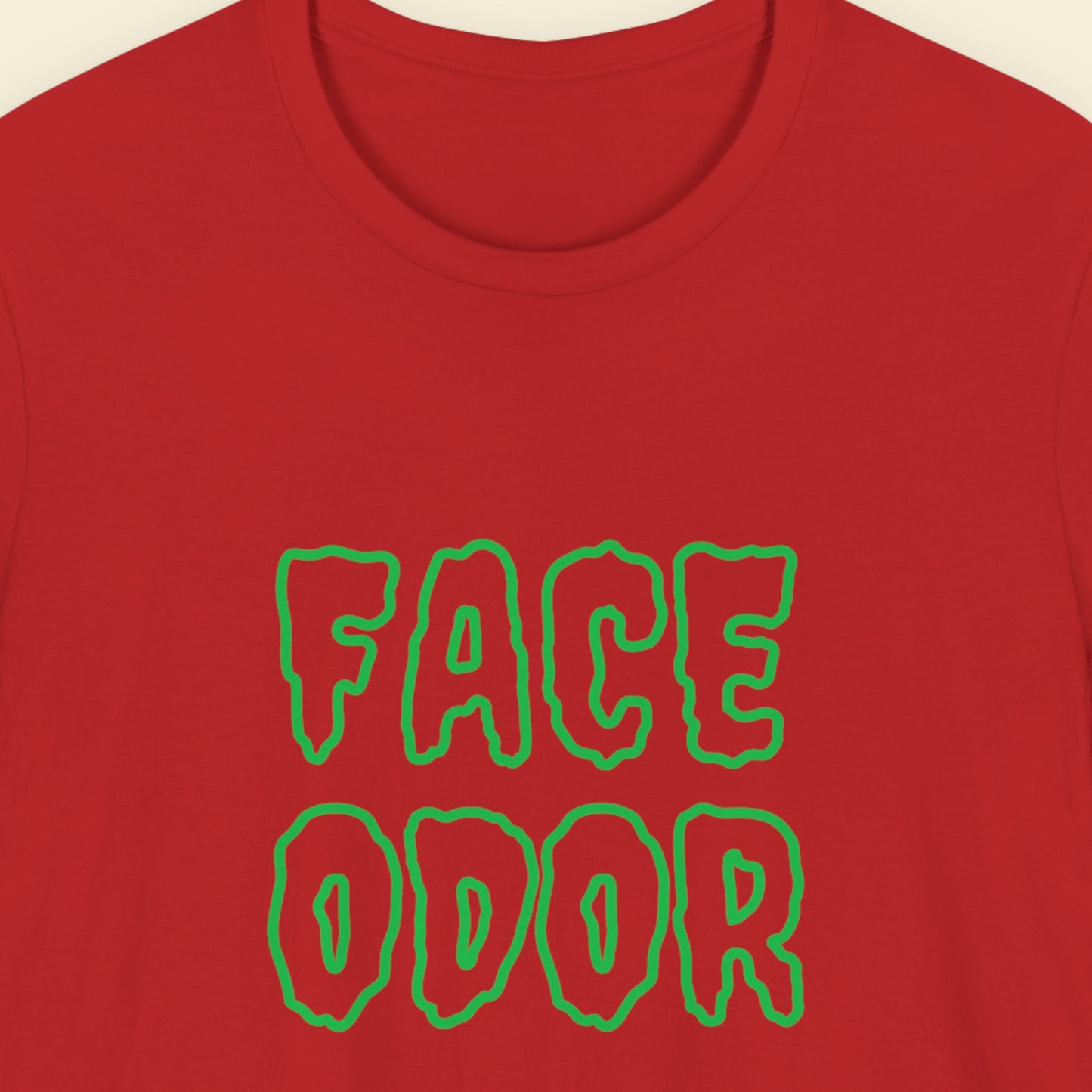 Red t-shirt with humorous colorful text on a beige background.