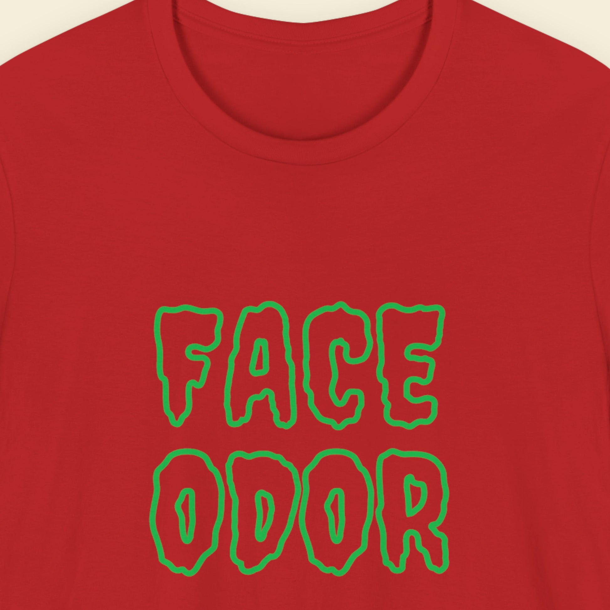 Red t-shirt with humorous colorful text on a beige background.