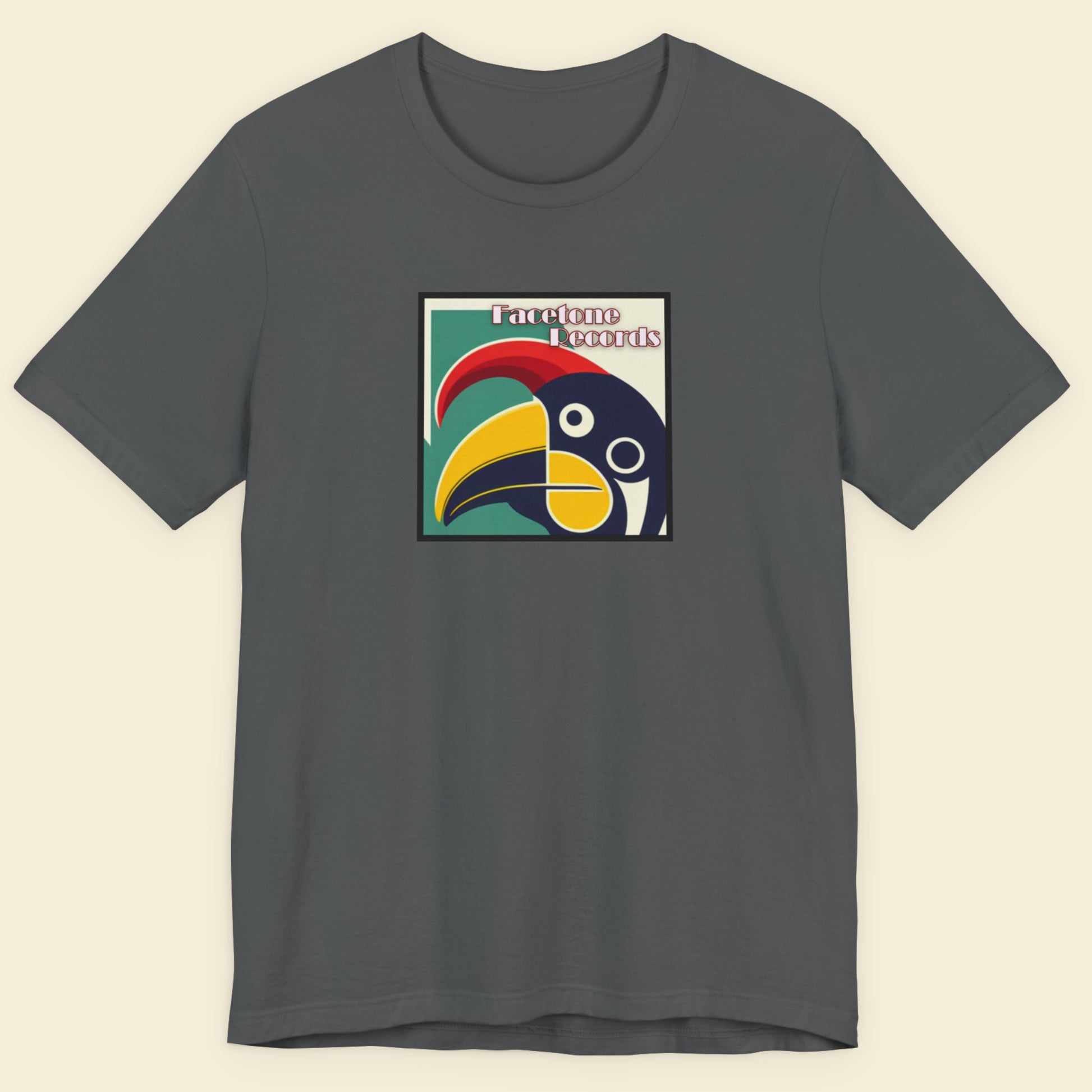 Gray t-shirt with a colorful toucan graphic on a beige background