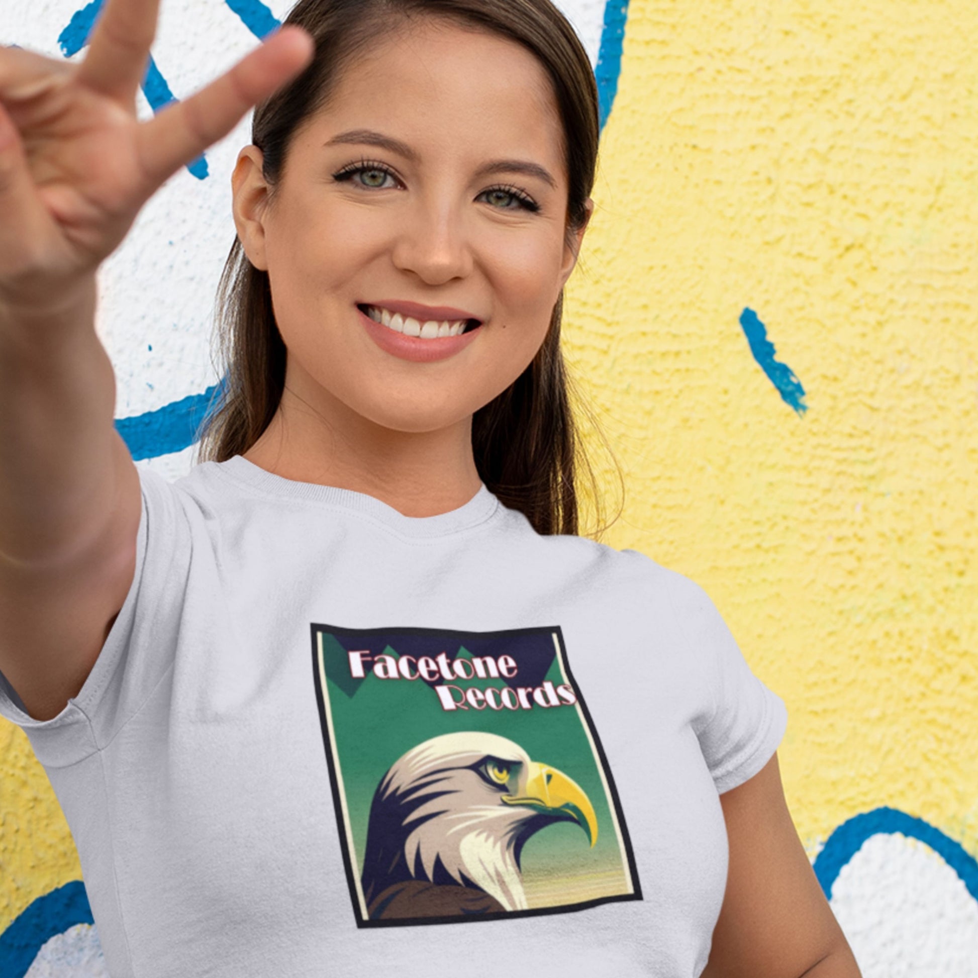 Woman wearing a white t-shirt with an eagle graphic and 'Facetone Records' text against a colorful background