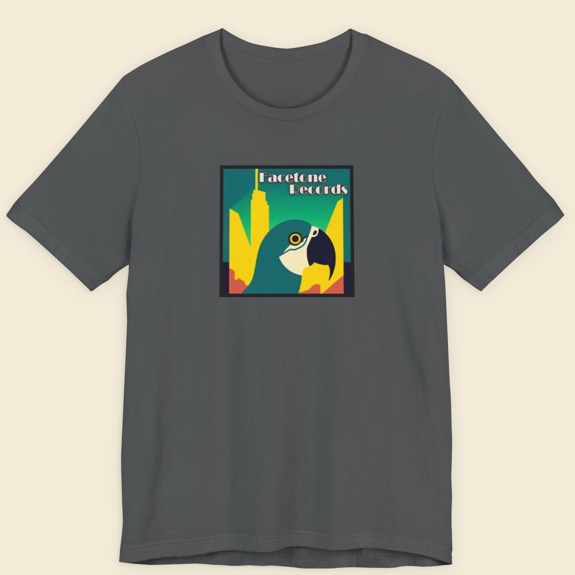 Gray t-shirt with a colorful graphic of a macaw on a beige background