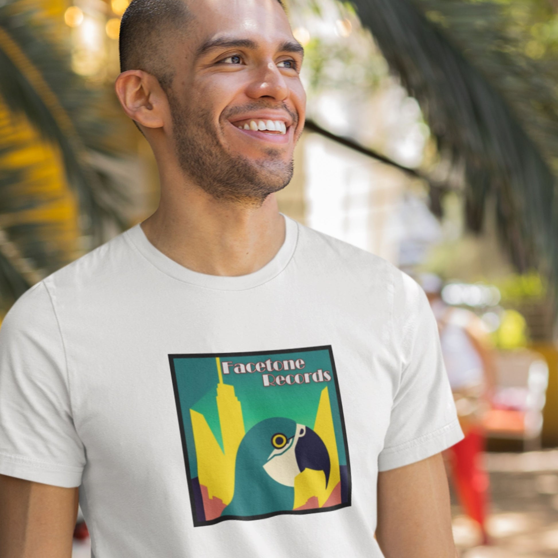 Man wearing a white t-shirt with a colorful macaw graphic design outdoors