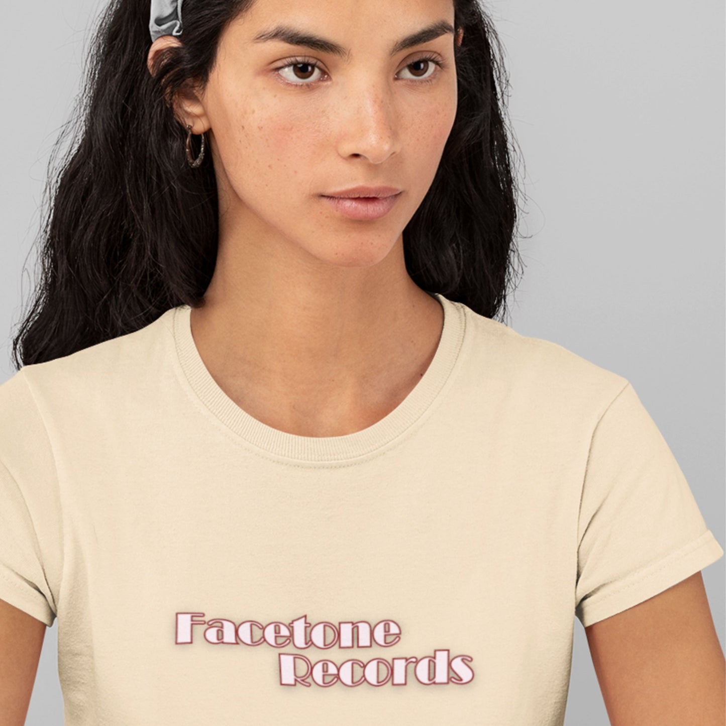 Woman wearing a beige t-shirt with 'Facetone Records' text on a gray background