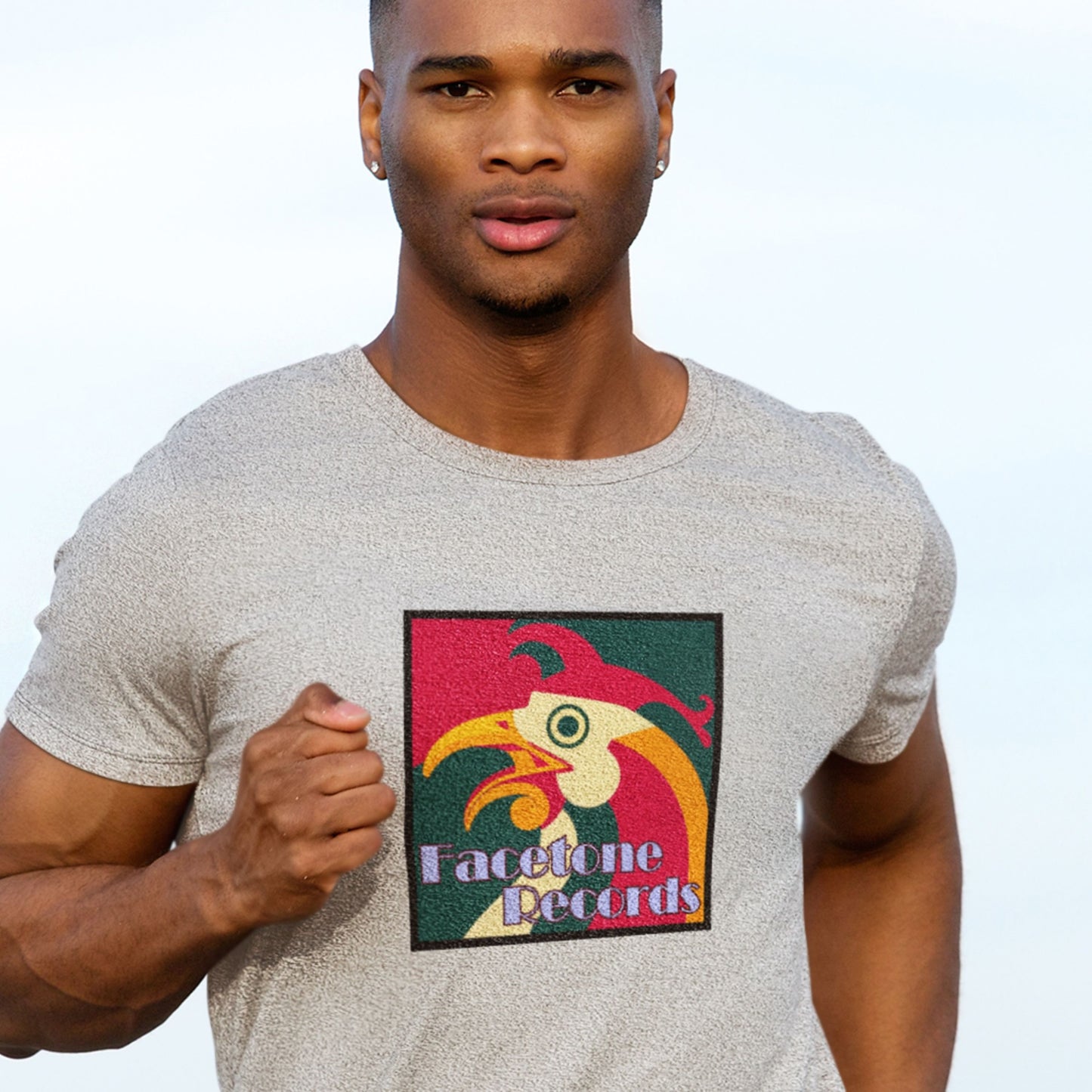 Man wearing a t-shirt with a colorful rooster graphic and 'Facetone Records' text on a plain background