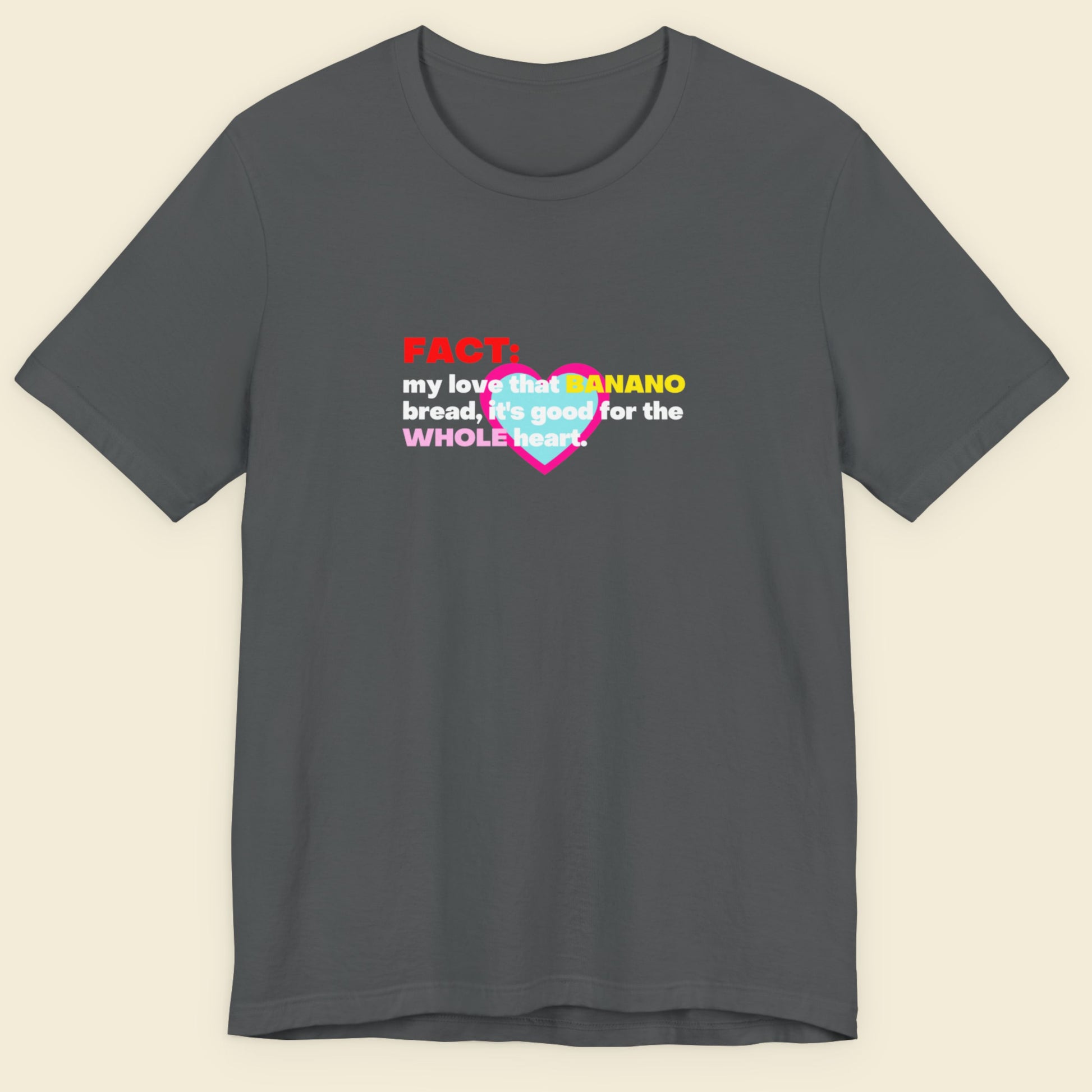 Gray t-shirt with colorful text design on a beige background.