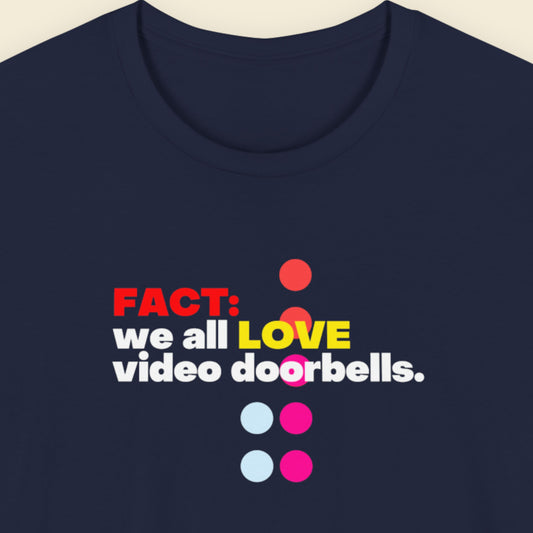 Navy blue t-shirt with humorous colorful text on a beige background.