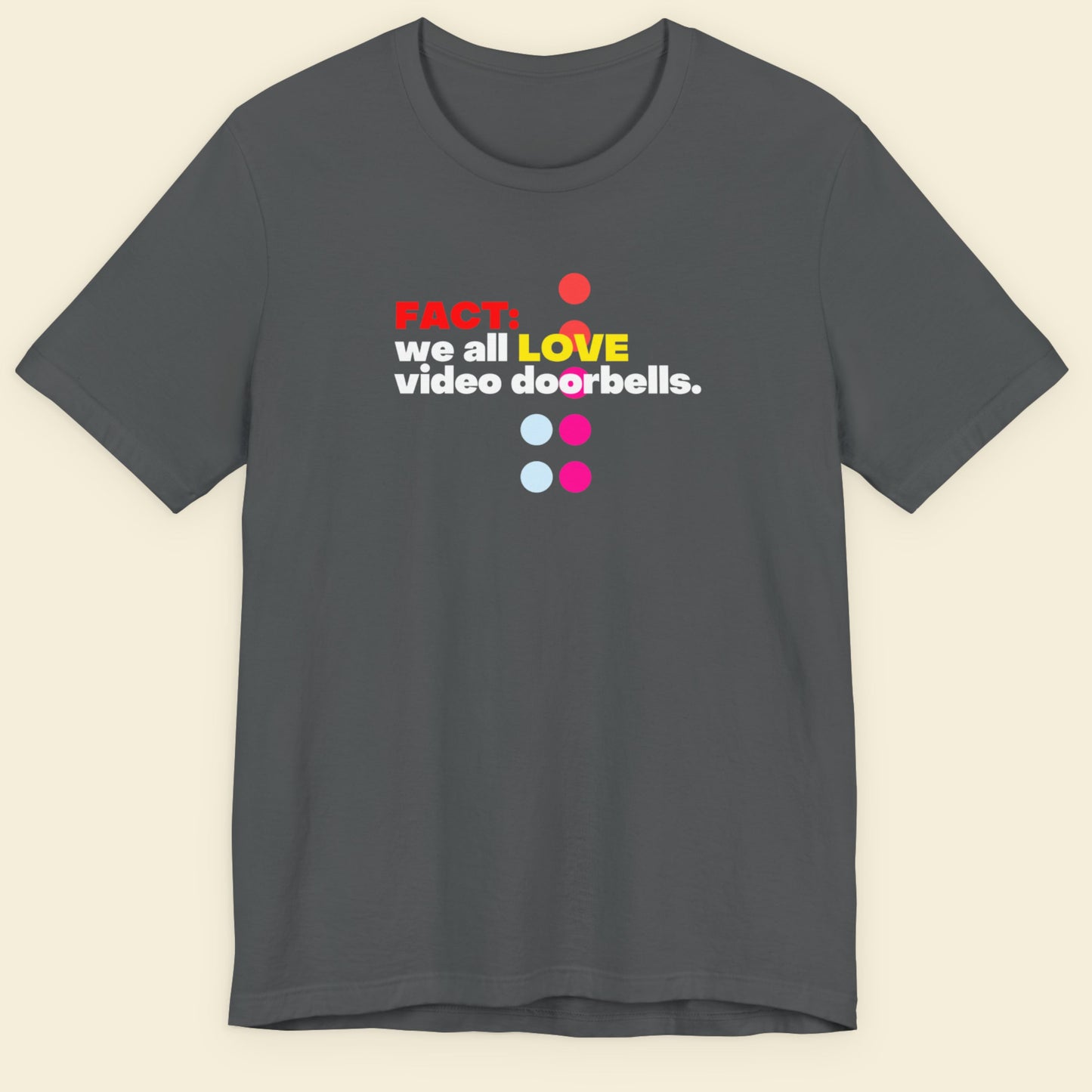 Gray t-shirt with colorful text and graphics on a beige background.