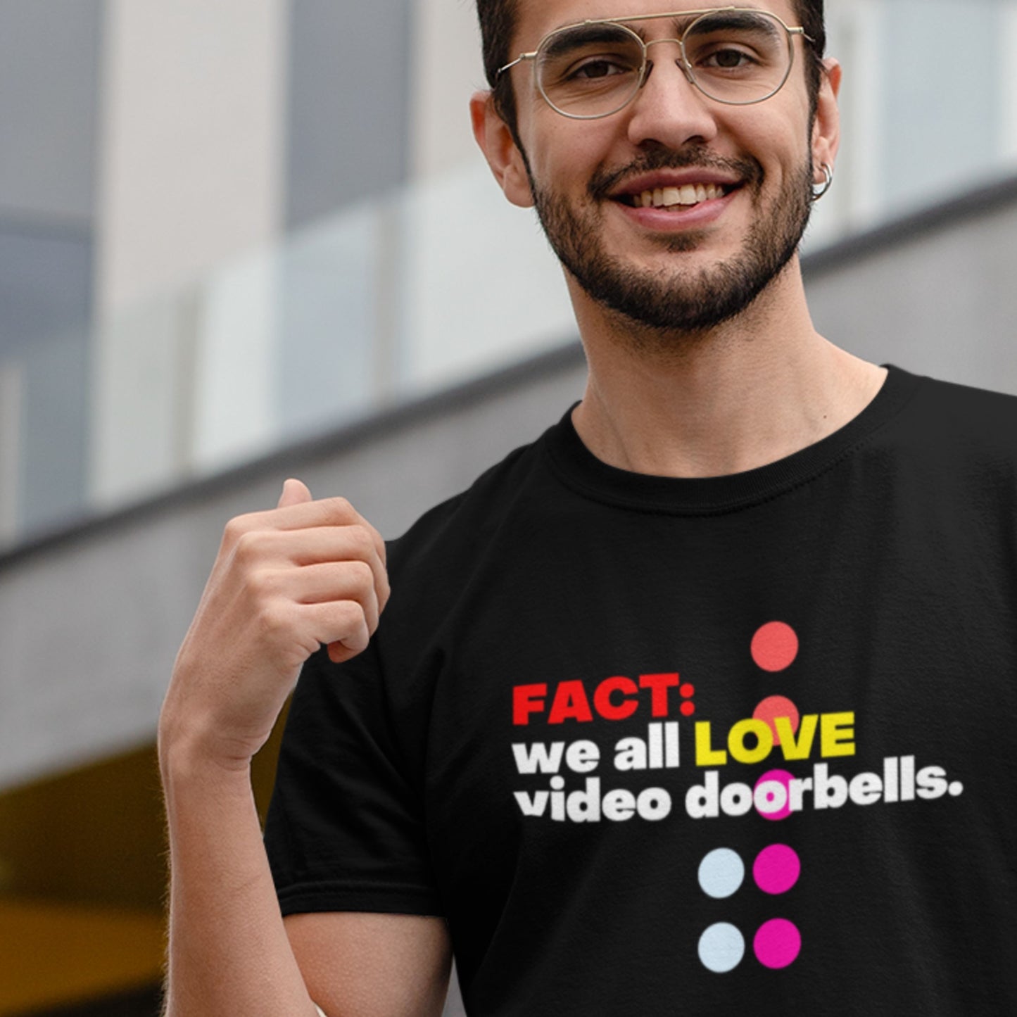Man wearing a black t-shirt with colorful text and graphics, standing outdoors.