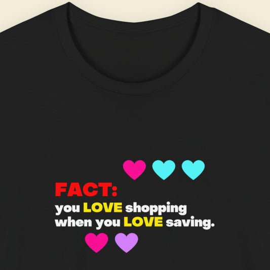 Black t-shirt with colorful text and hearts on a beige background.
