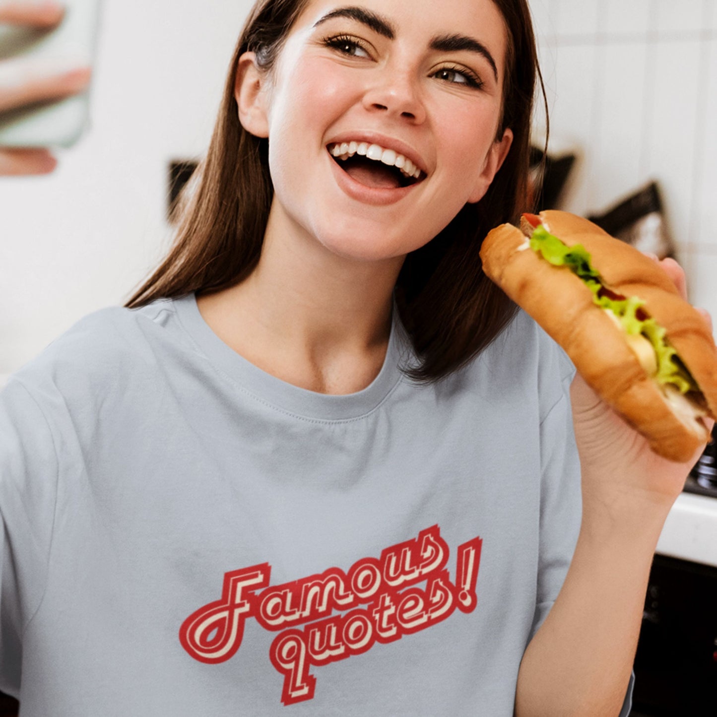 Woman wearing a 'Famous quotes!' t-shirt holding a sandwich.
