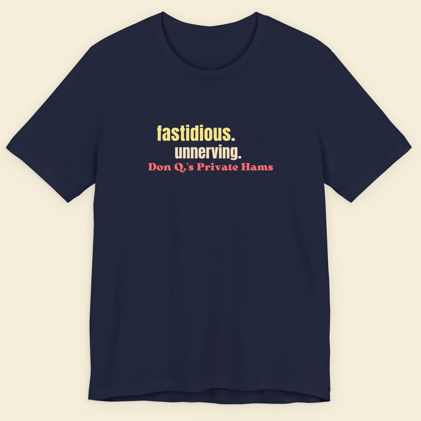 Navy blue t-shirt with colorful text on a beige background.