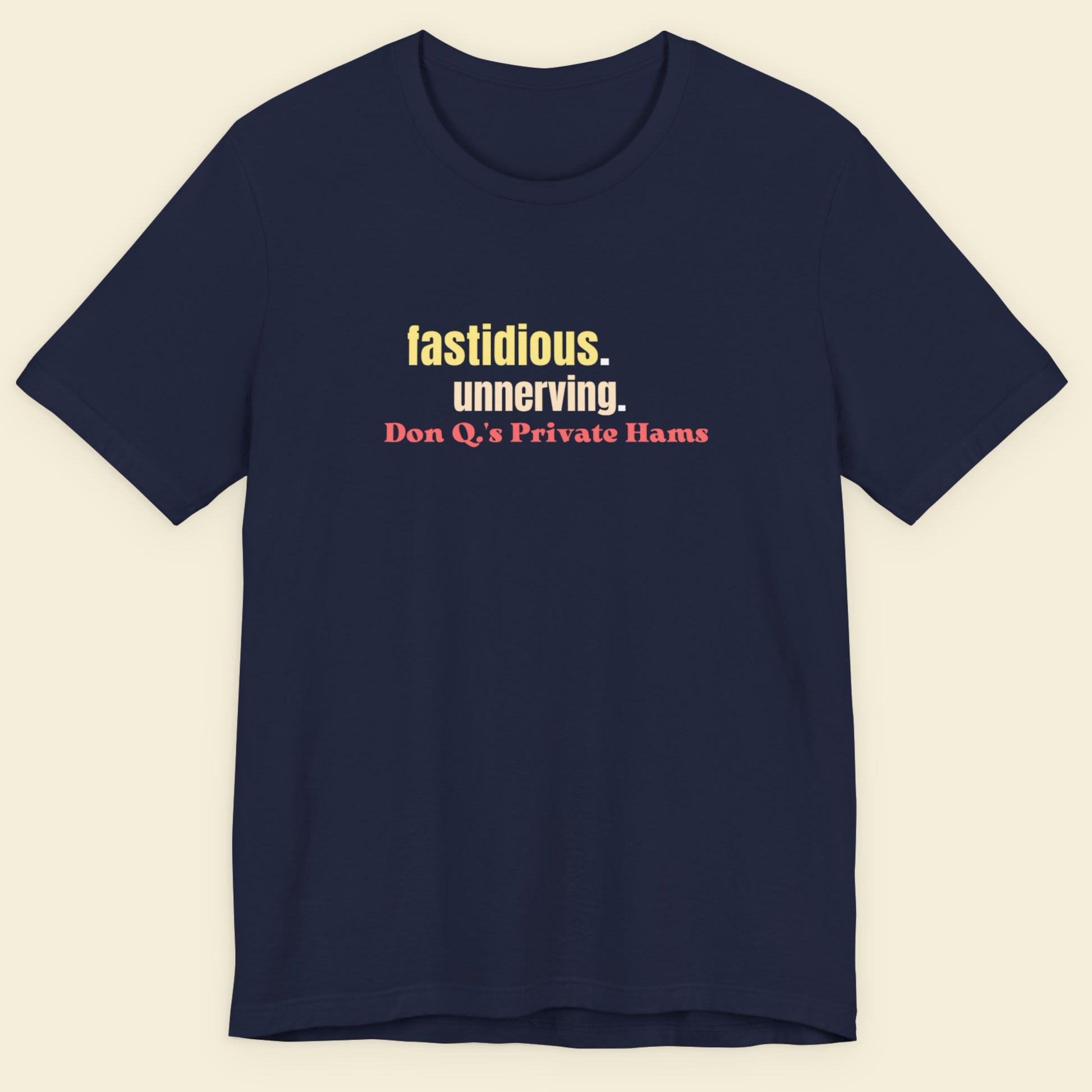 Navy blue t-shirt with colorful text on a beige background.