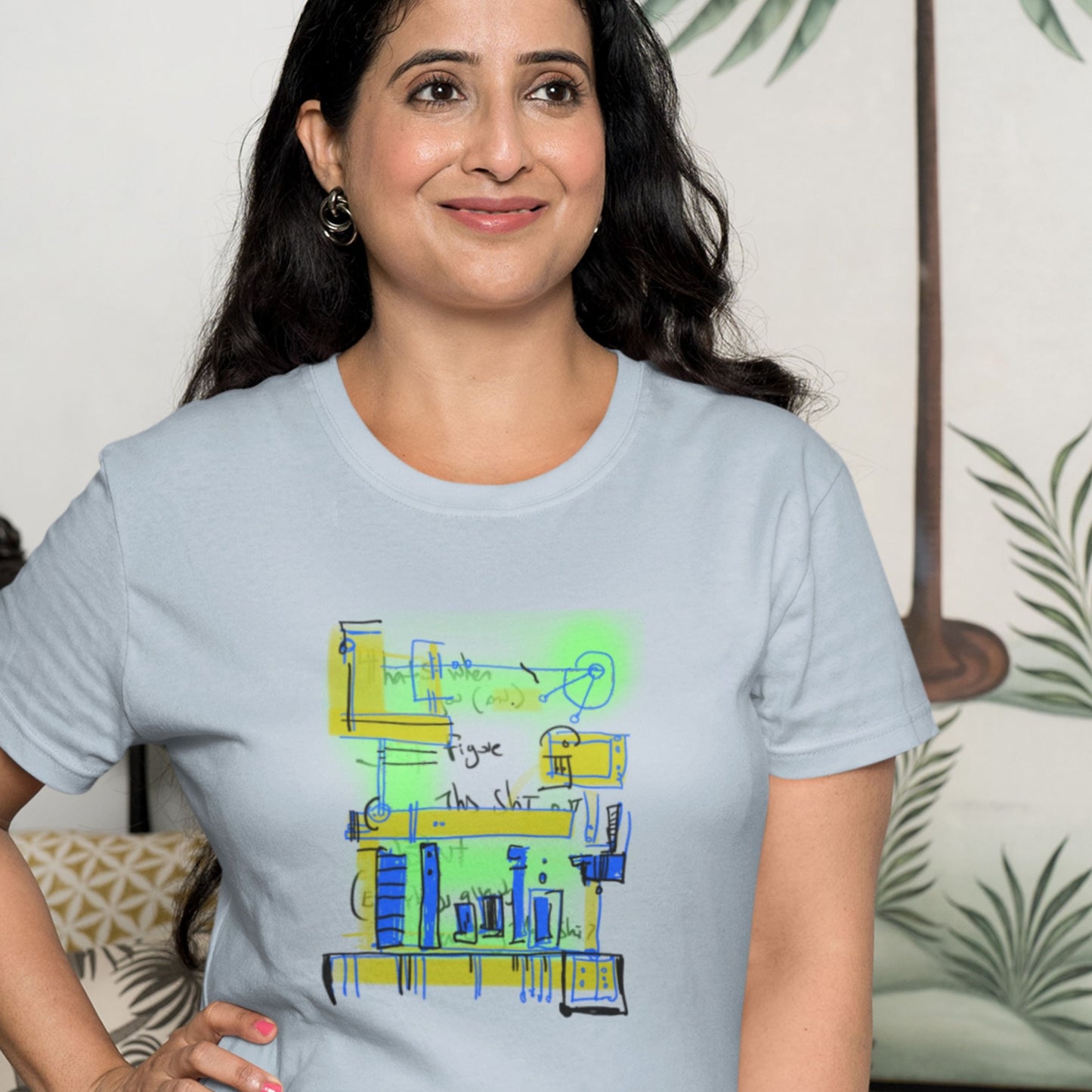 Woman wearing a blue t-shirt with a colorful abstract system drawing on a beige background in a living room.