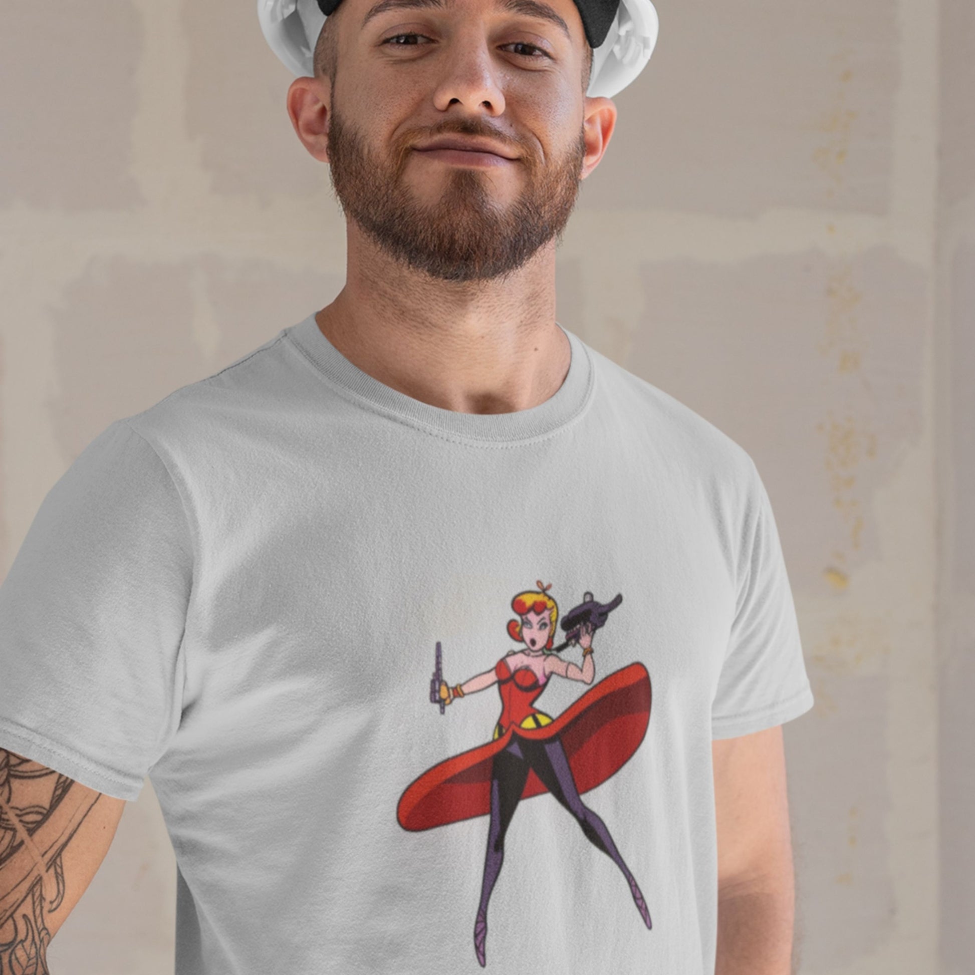 Worker man wearing a light grey t-shirt with a fun, colorful cartoon comic book illustration in front of some drywall.