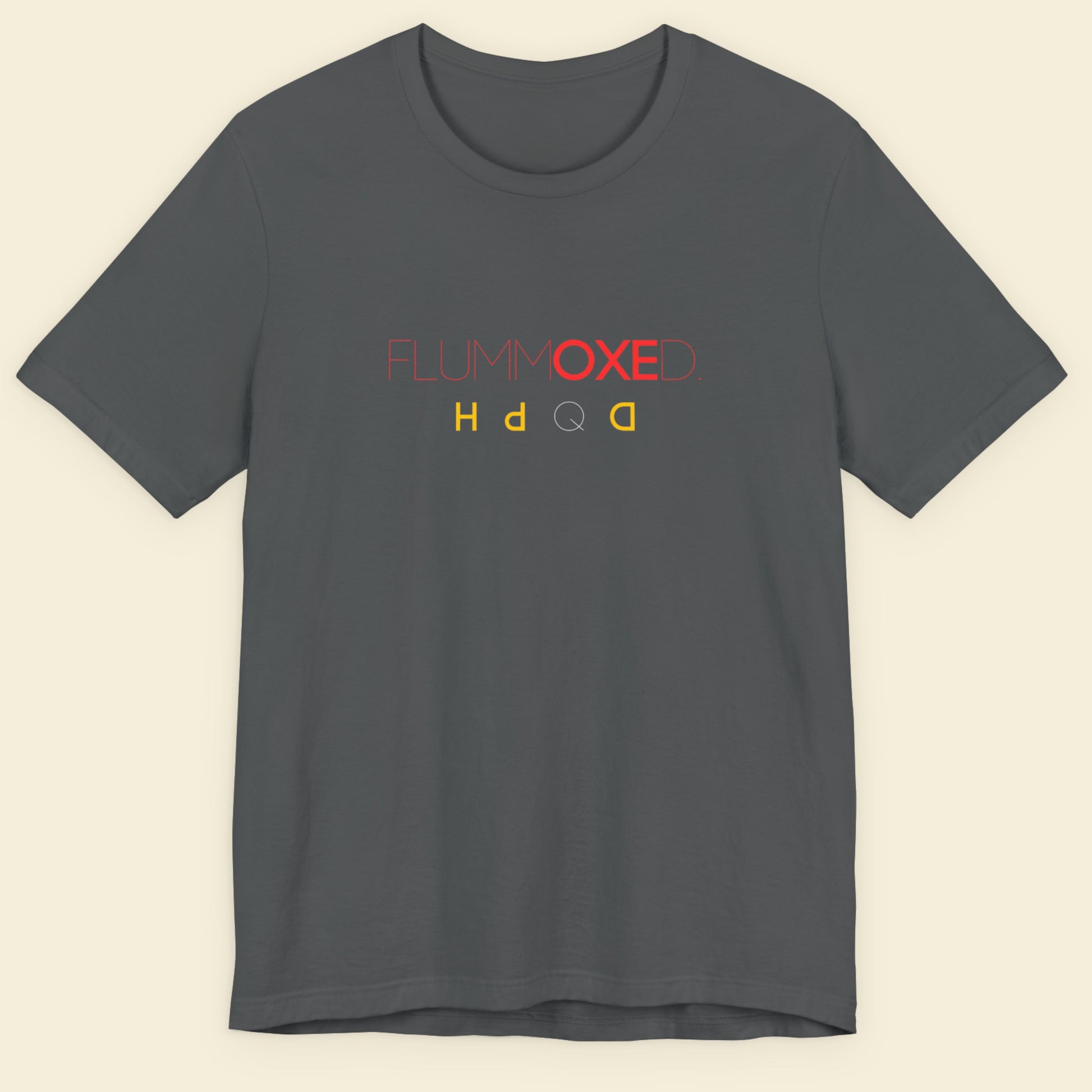 Gray t-shirt with colorful text design on a beige background.