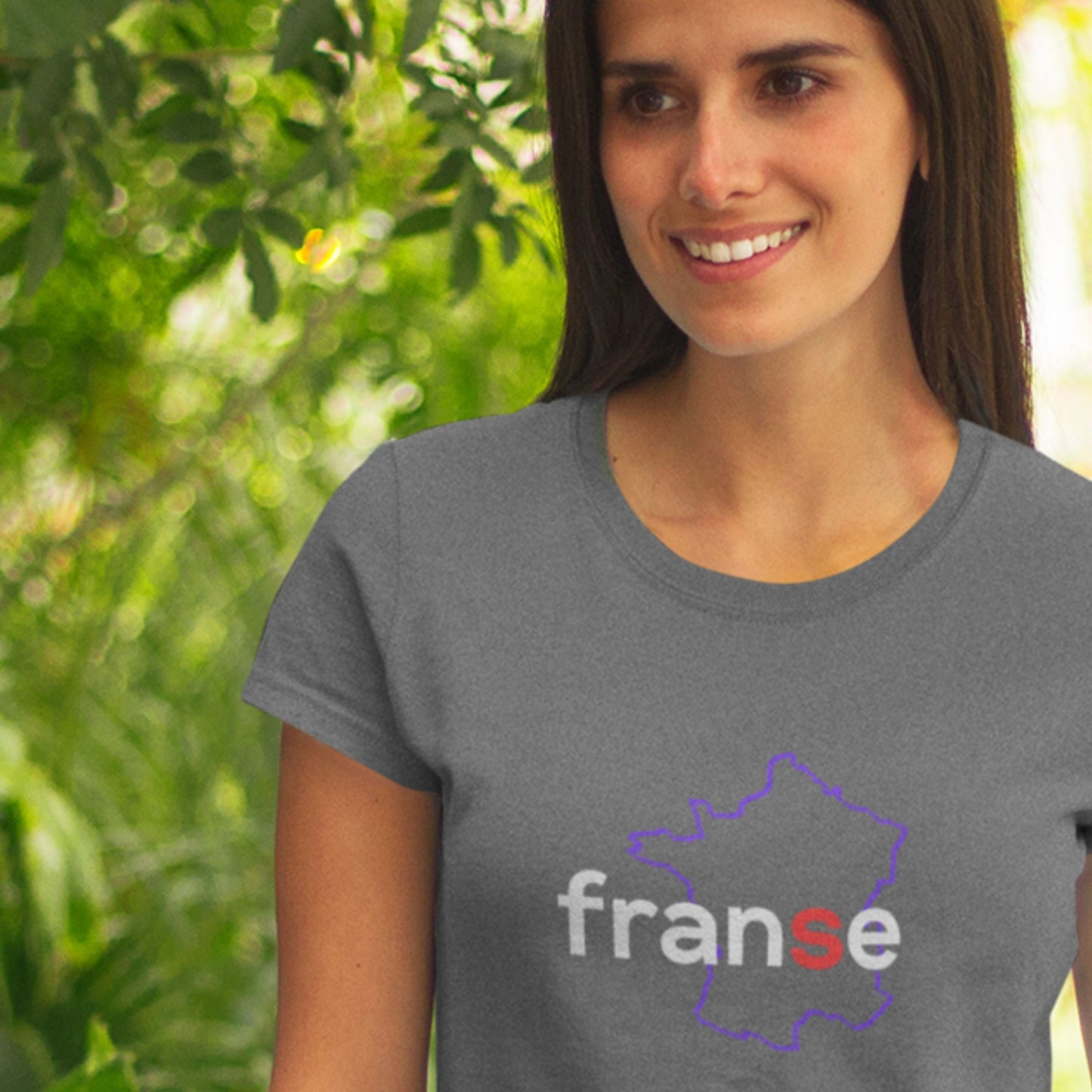 Woman wearing a gray t-shirt with 'franse' design outdoors.