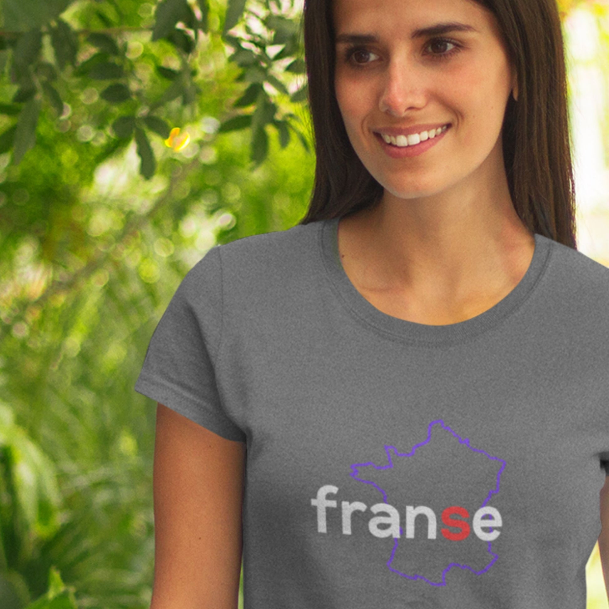 Woman wearing a gray t-shirt with 'franse' design outdoors.