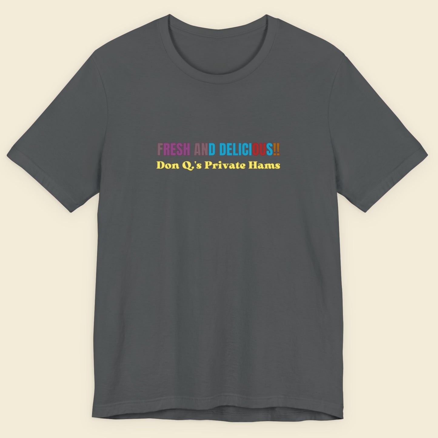 Gray t-shirt with colorful text on a beige background.