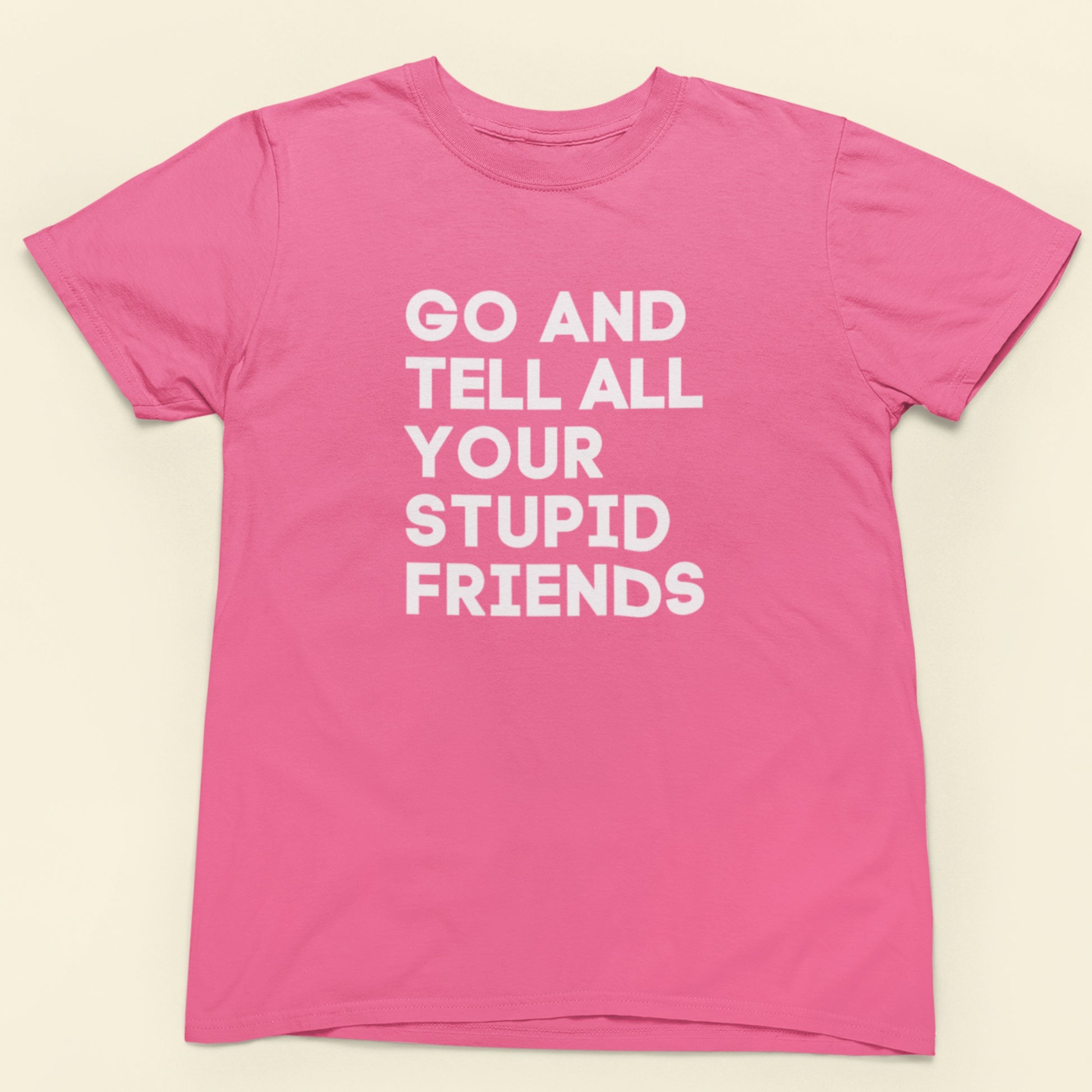 Pink t-shirt with white text on a beige background