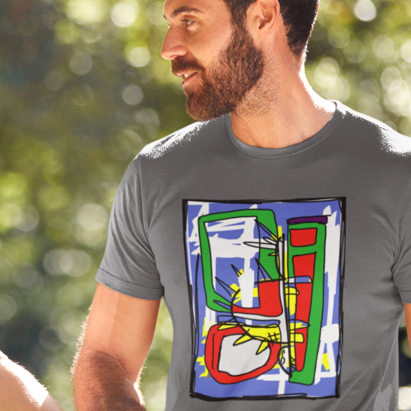 Man wearing a grey shirt with a colorful abstract drawing.