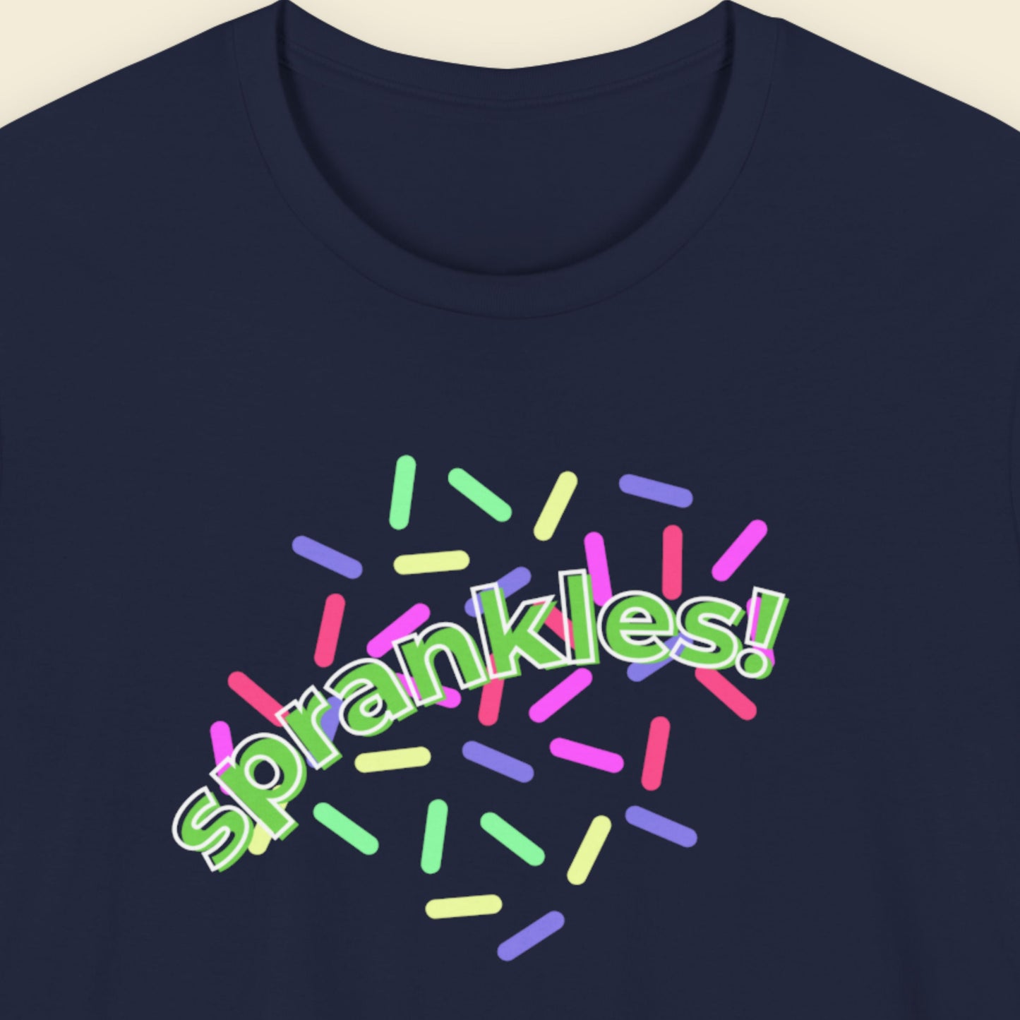 Navy blue t-shirt with humorous colorful text on a beige background.