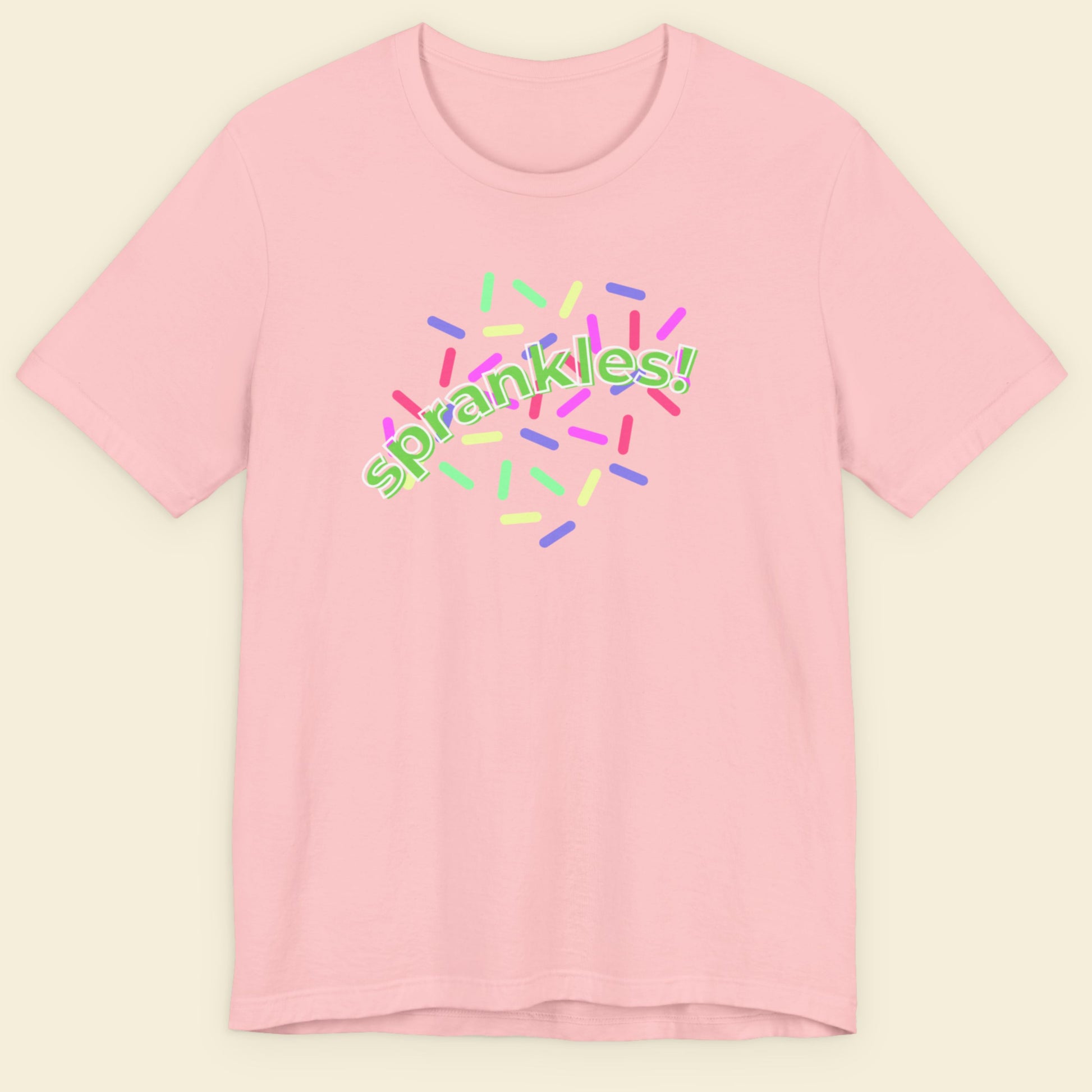 Pink t-shirt with 'sprankles!' text and colorful sprinkles design on a beige background.