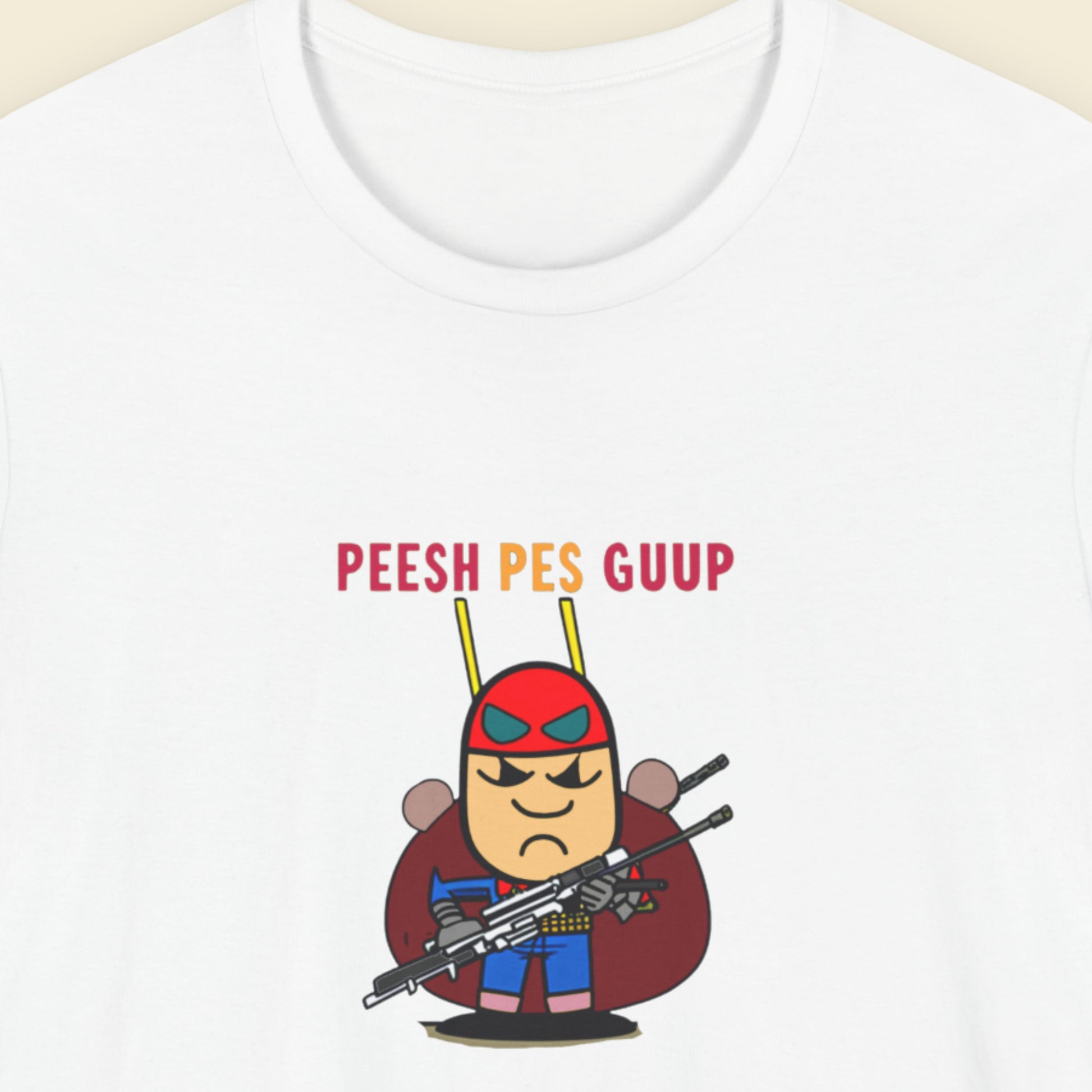 White t-shirt with a fun, colorful cartoon character illustration on a beige background.