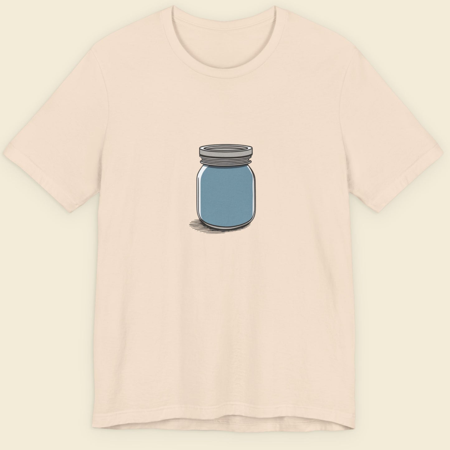 Beige shirt with a drawing of a blue jar against a beige background.