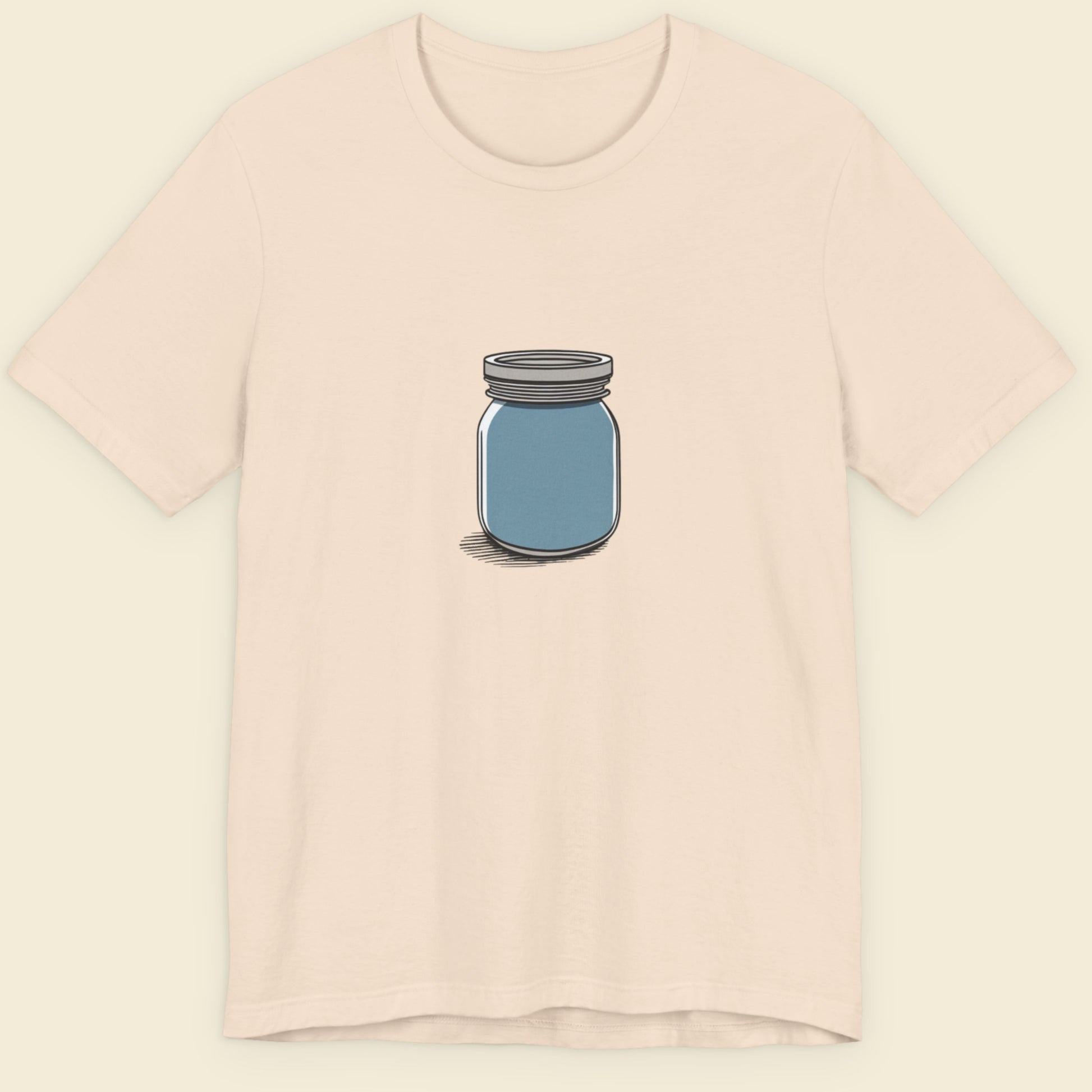 Beige shirt with a drawing of a blue jar against a beige background.