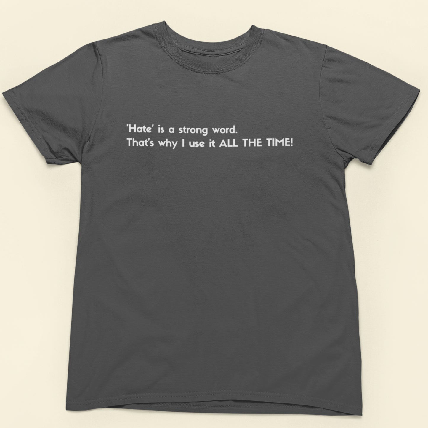 Gray t-shirt with humorous text on a beige background