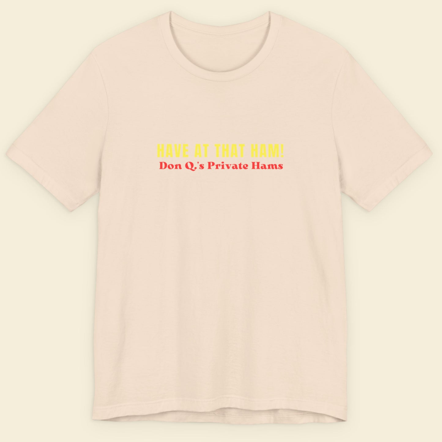 beige t-shirt with yellow and red text on a beige background