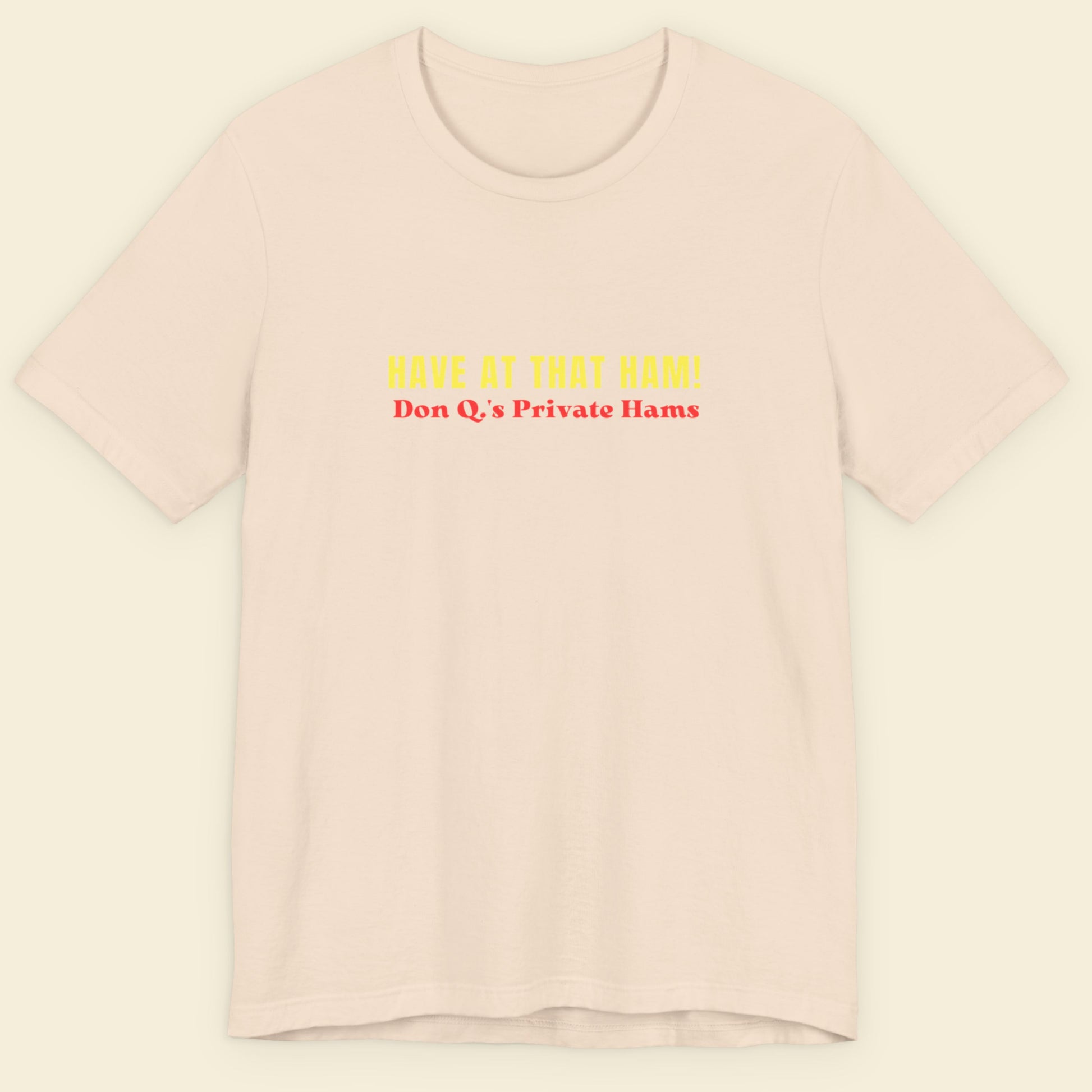 beige t-shirt with yellow and red text on a beige background