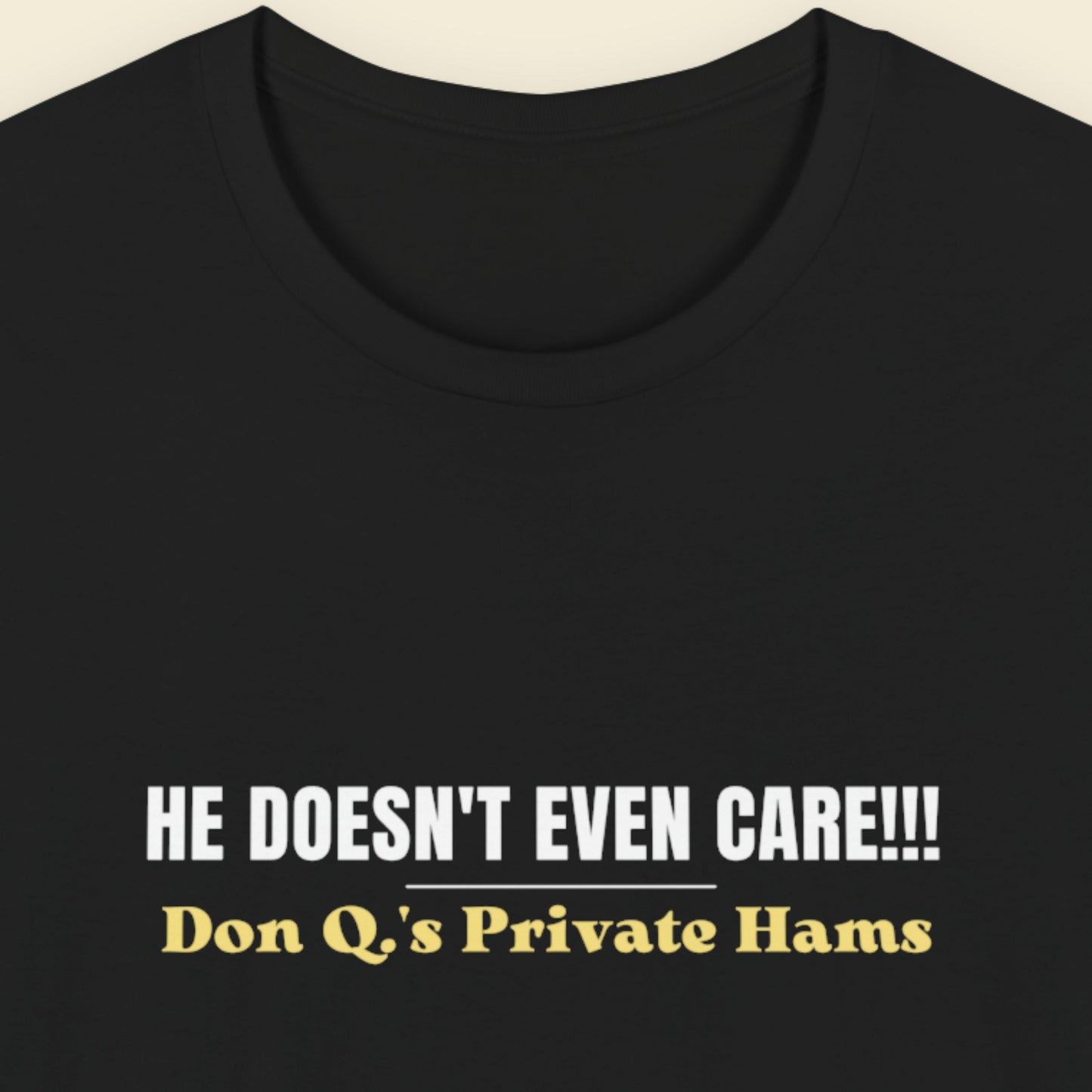 Black t-shirt with white and yellow text on a beige background.