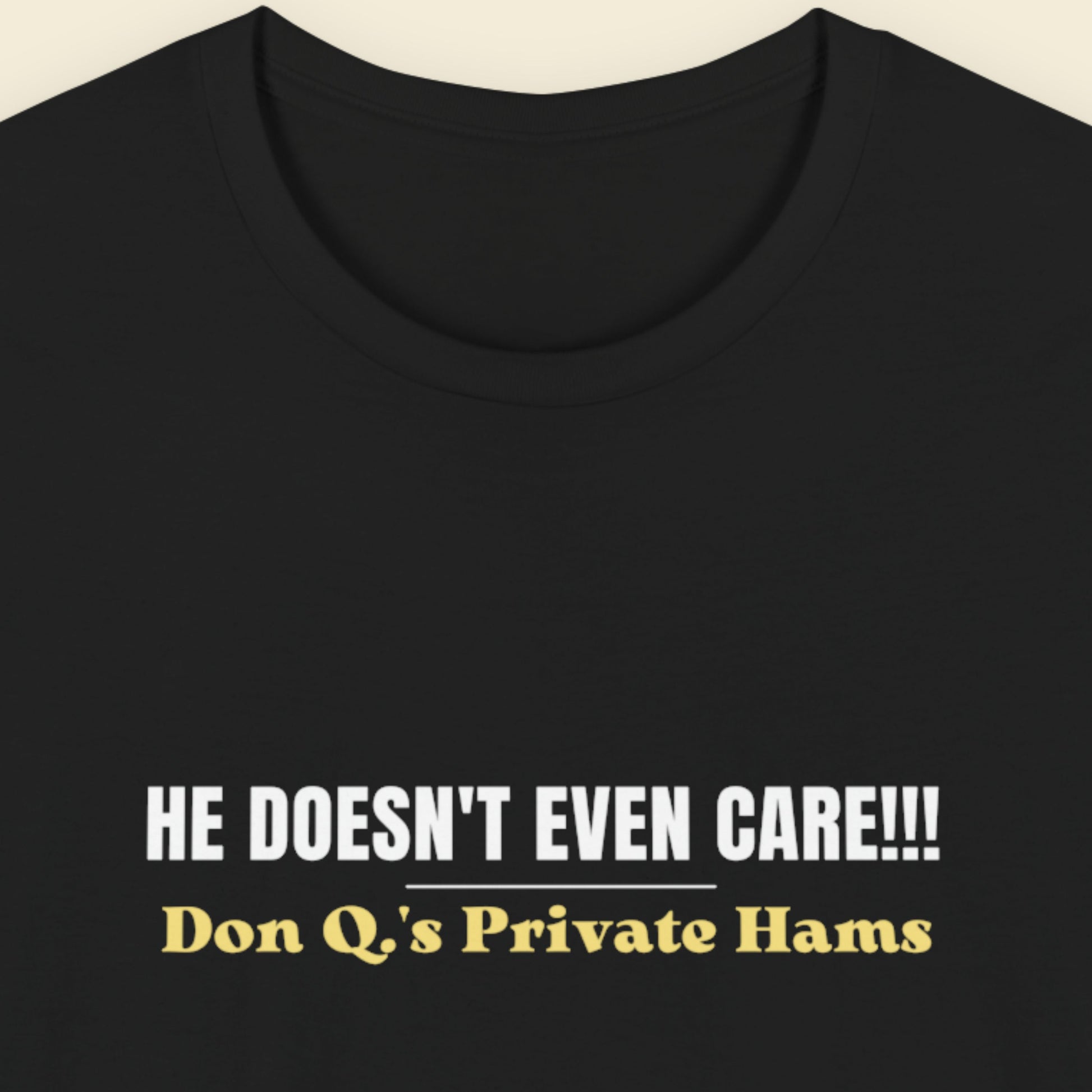Black t-shirt with white and yellow text on a beige background.