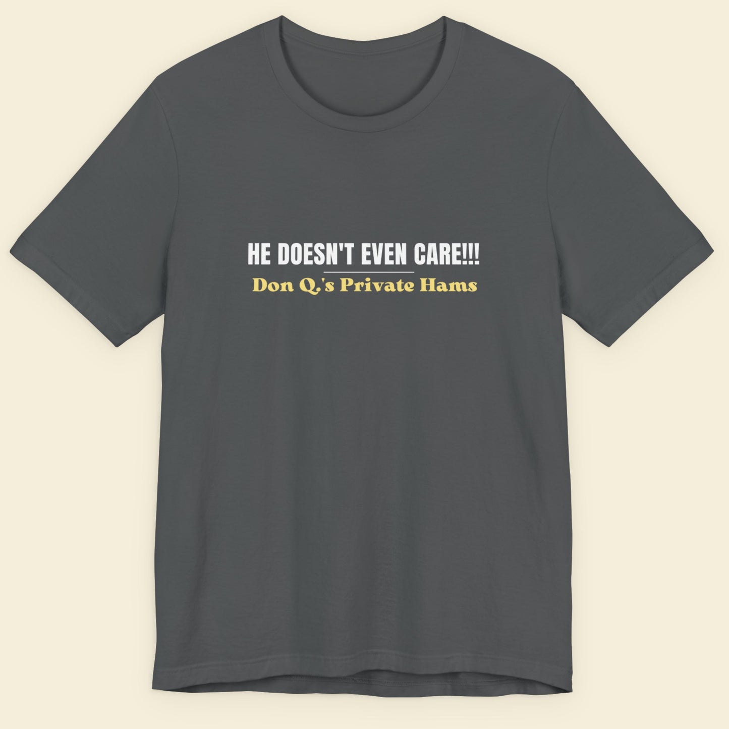 Grey t-shirt with humorous colorful text on a beige background.