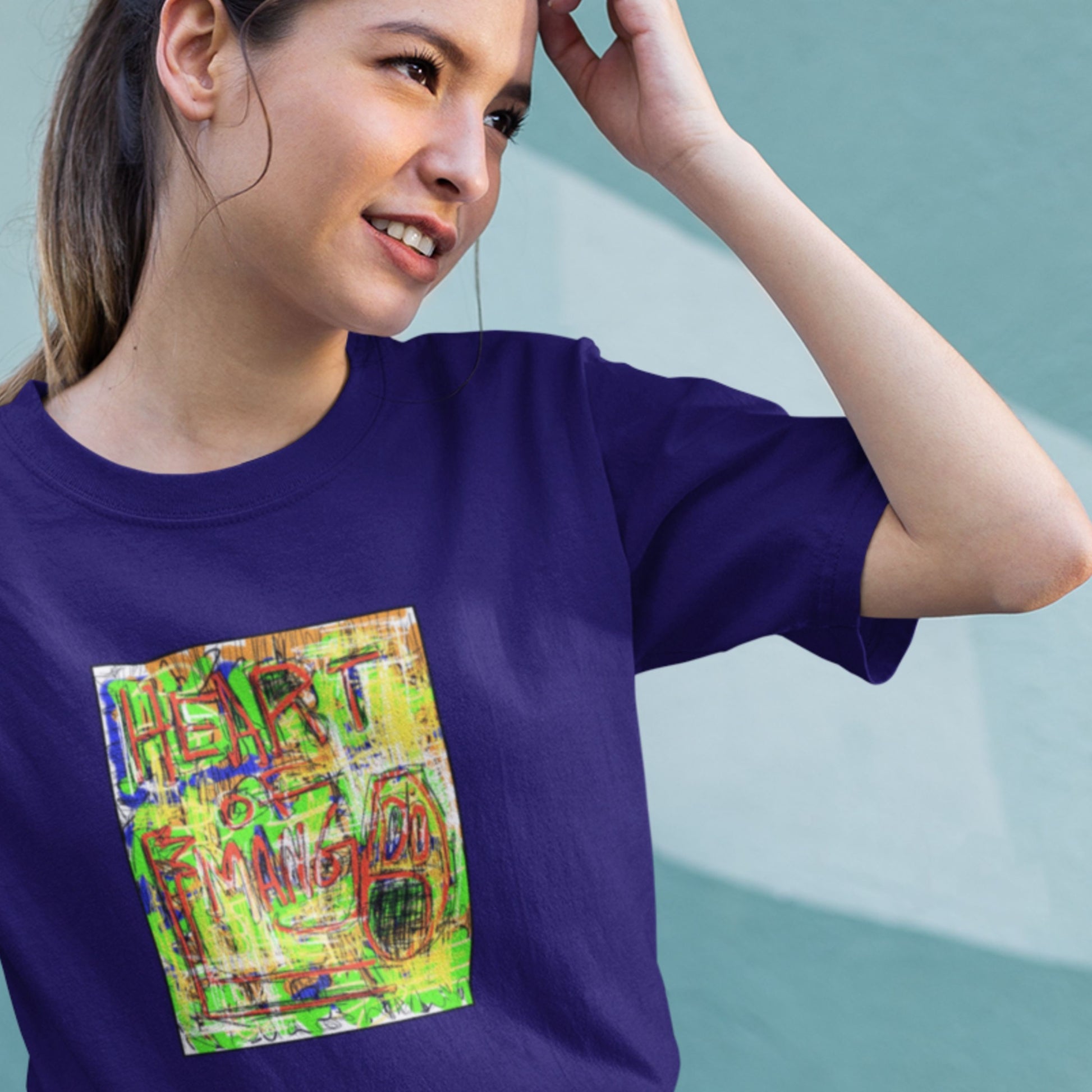 Woman wearing a blue t-shirt with a colorful abstract drawing on a beige background.