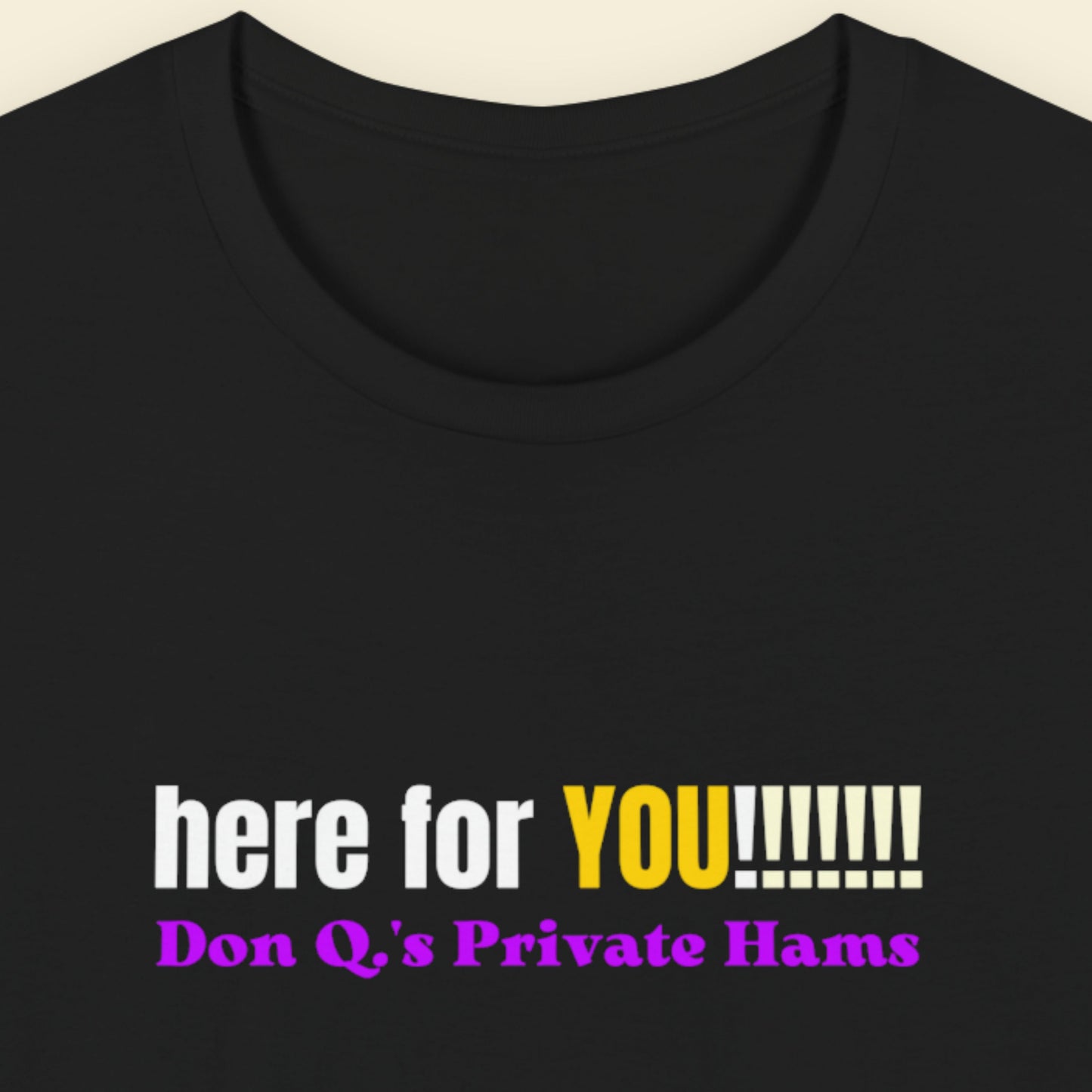 Black t-shirt with colorful text on a beige background.