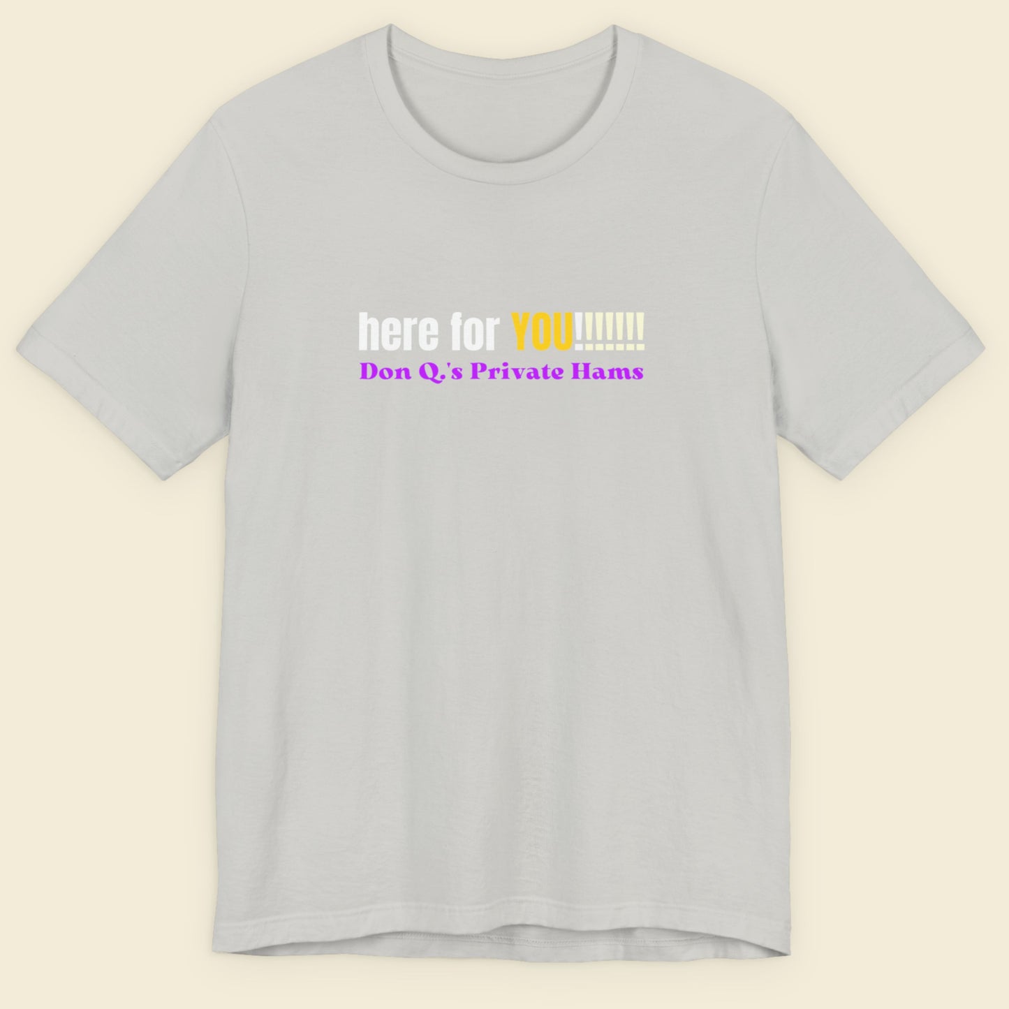 Grey t-shirt with humorous colorful text on a beige background.