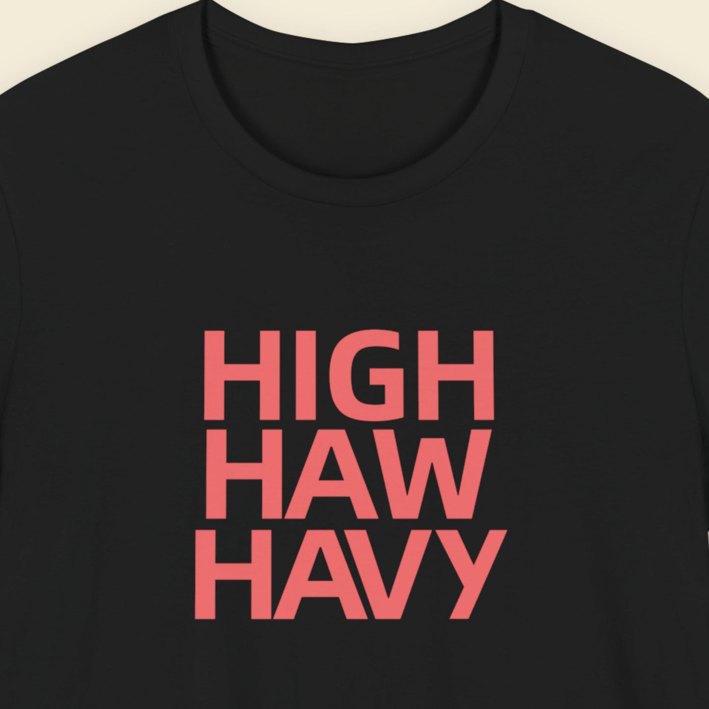 Black t-shirt with multicolored nonsensical  'high haw havy' text on a beige background.