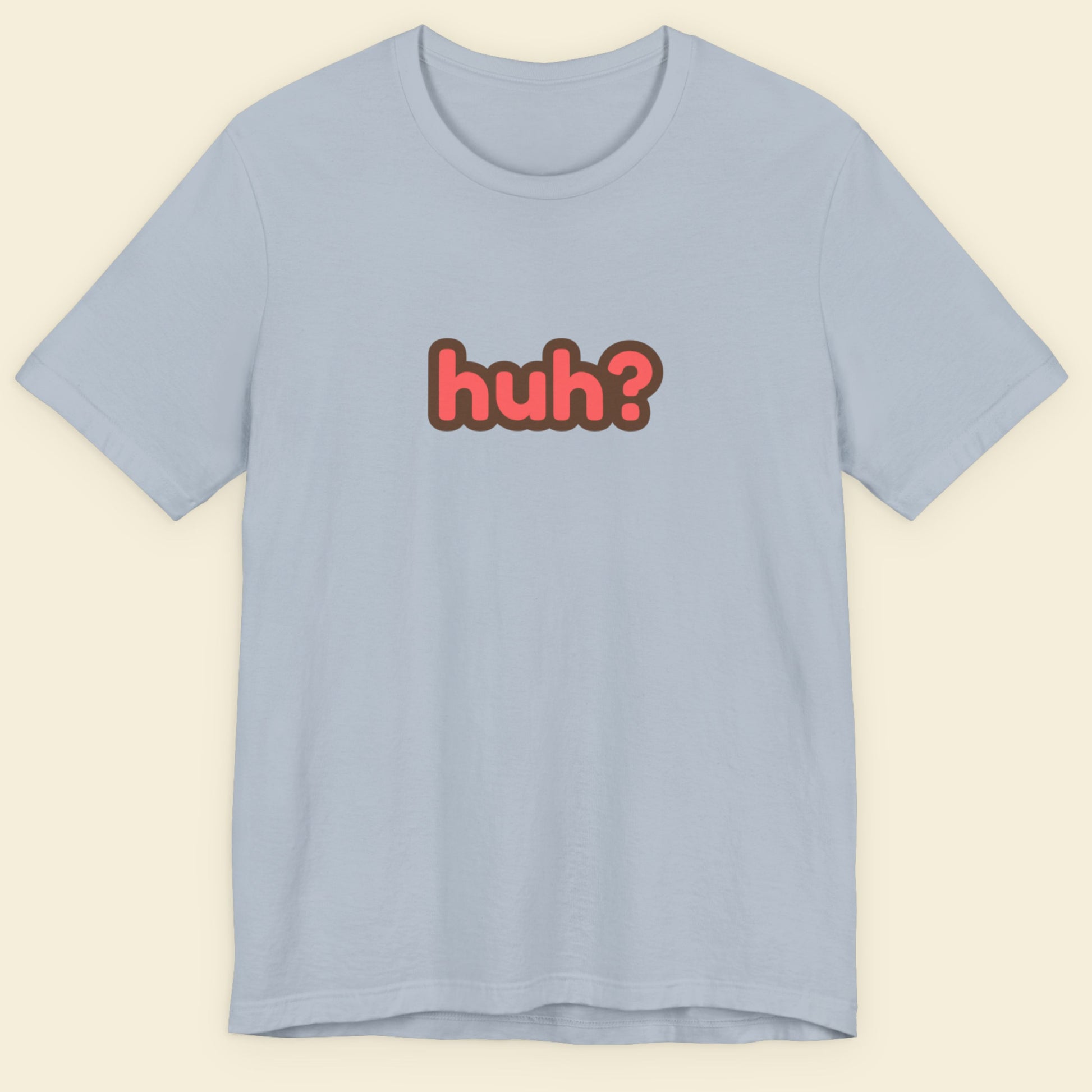 Light blue t-shirt with multicolored 'huh?' text on a beige background.