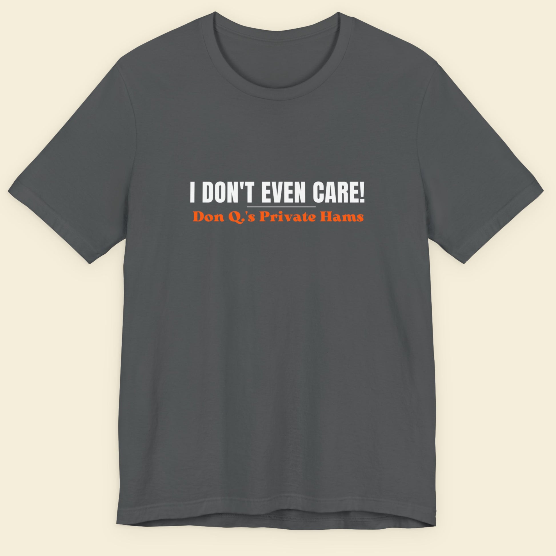 Gray t-shirt with humorous text design on a beige background.
