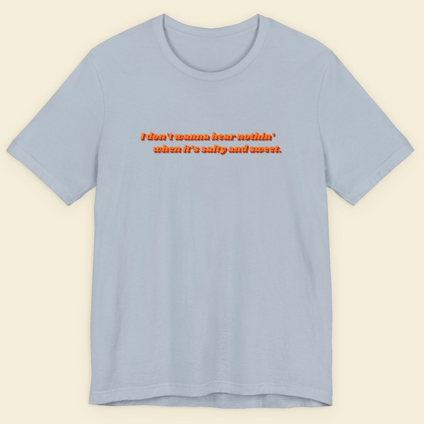 Light blue t-shirt with red text on a beige background