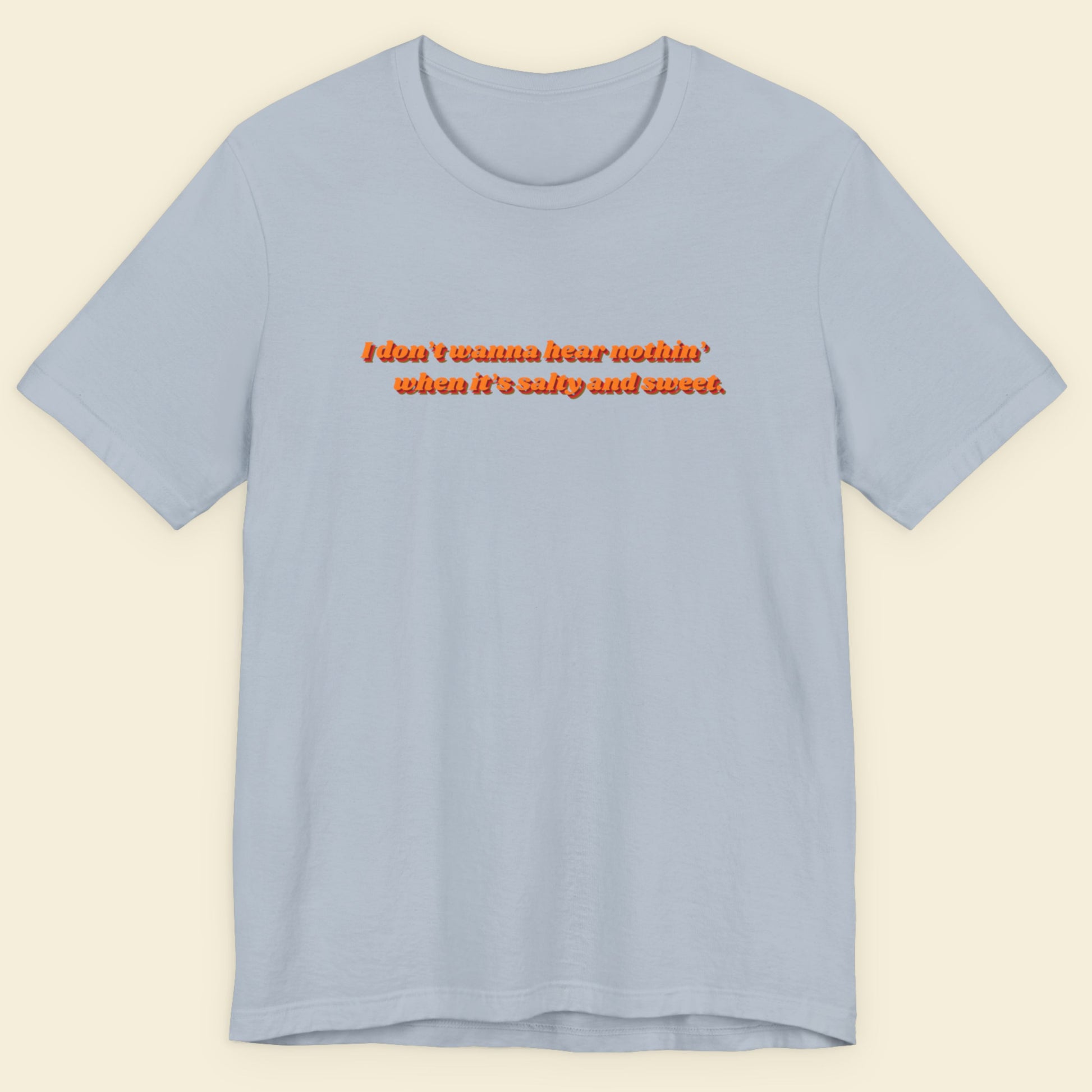 Light blue t-shirt with red text on a beige background