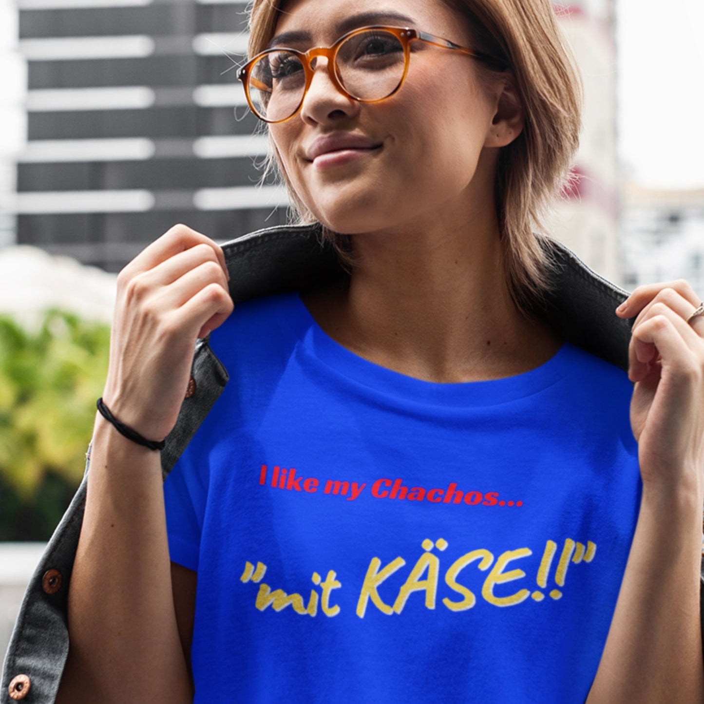 Woman wearing a blue t-shirt with German text, standing outdoors.