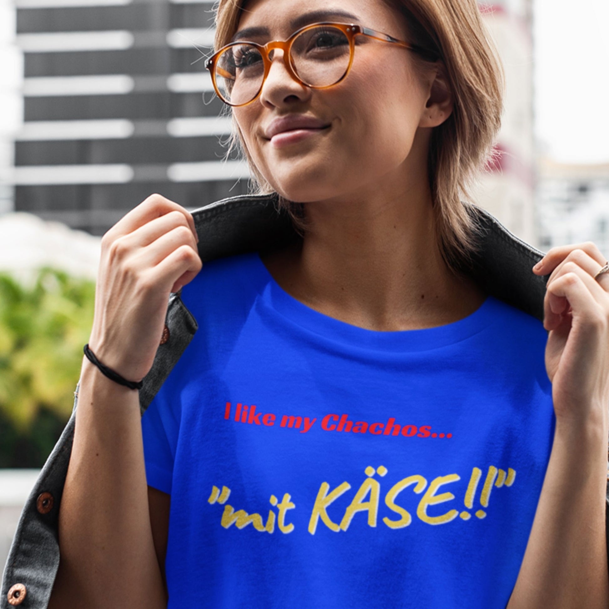 Woman wearing a blue t-shirt with German text, standing outdoors.