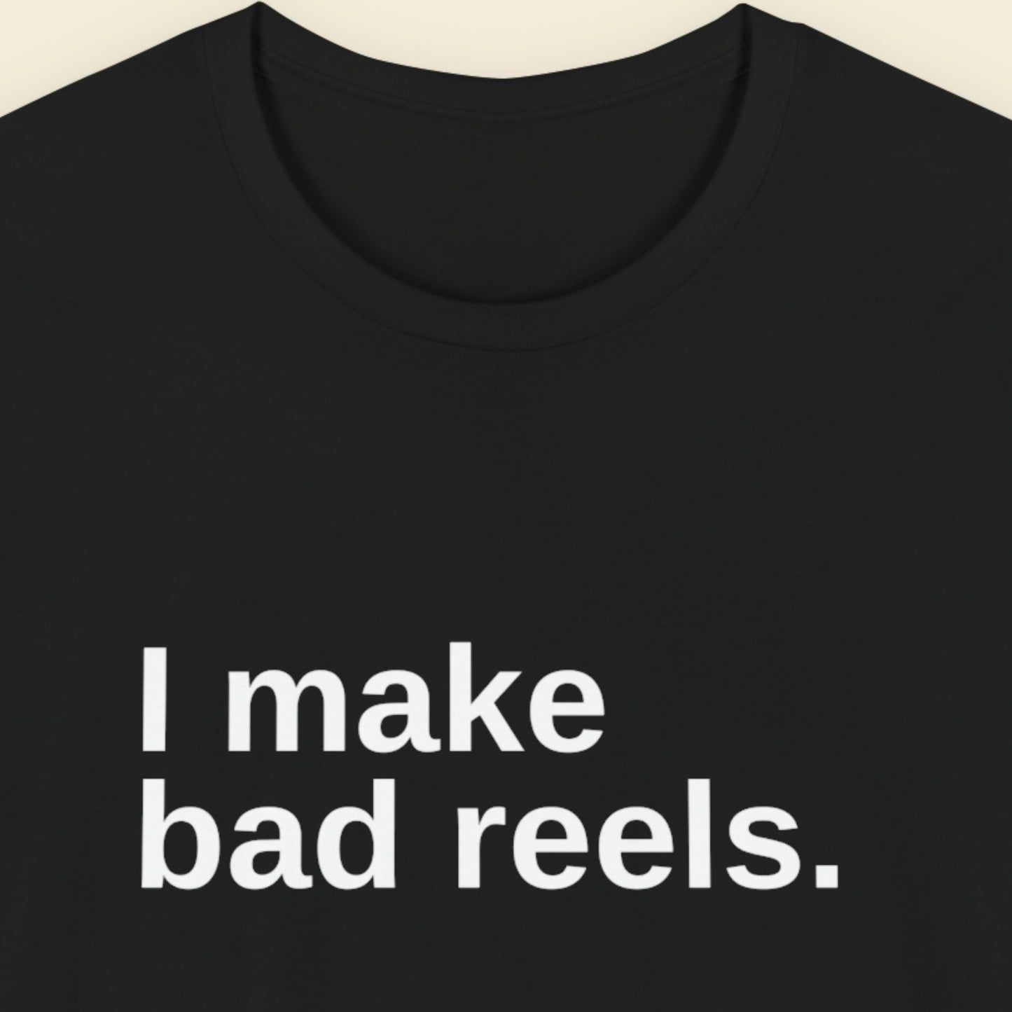 Black t-shirt with white text 'I make bad reels' on a beige background.