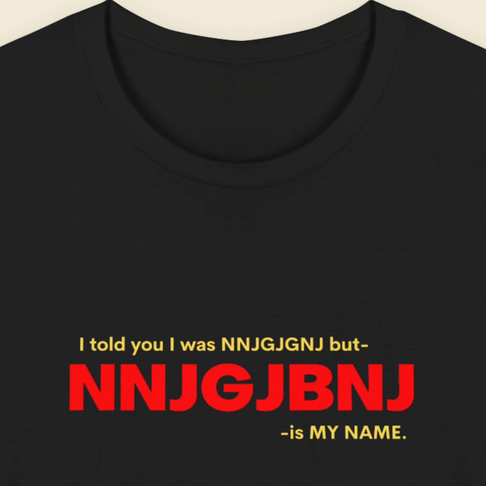 Black t-shirt with red and yellow text on a beige background.