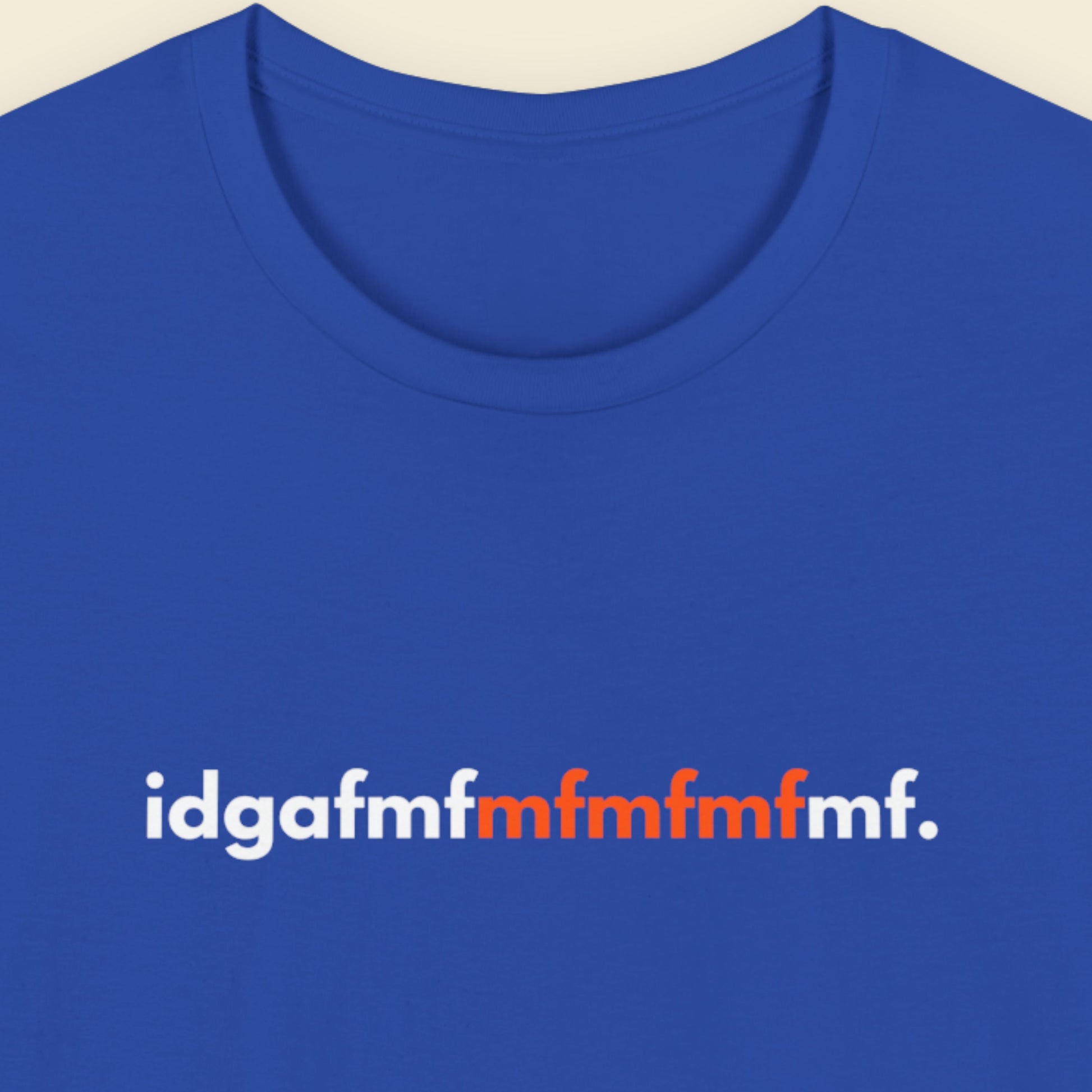 Blue t-shirt with white and orange text on a beige background.